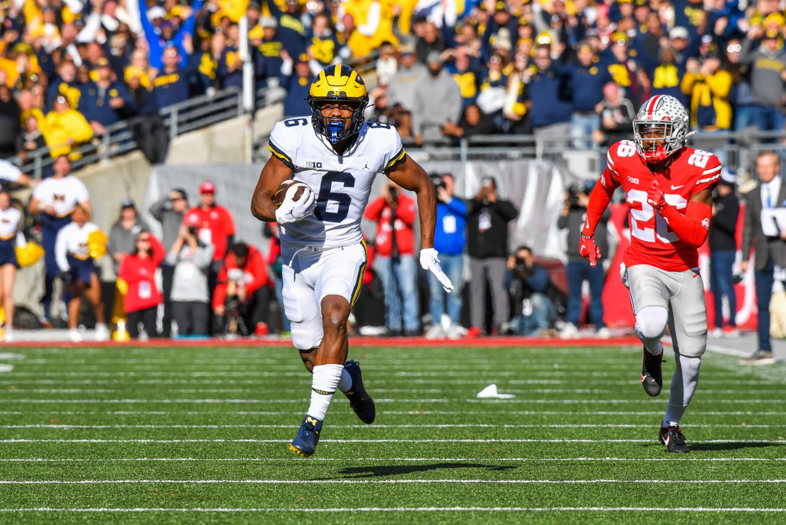 COLUMBUS, OHIO - NOVEMBER 26: Cornelius Johnson #6 of the Michigan Wolverines runs downfield for touchdown while chased by Cameron Brown #26 of the Ohio State Buckeyes during the first half of a college football game at Ohio Stadium on November 26, 2022 in Columbus, Ohio. (Photo by Aaron J. Thornton/Getty Images) COLUMBUS, OHIO - NOVEMBER 26: Cornelius Johnson #6 of the Michigan Wolverines runs downfield for touchdown while chased by Cameron Brown #26 of the Ohio State Buckeyes during the first half of a college football game at Ohio Stadium on November 26, 2022 in Columbus, Ohio. (Photo by Aaron J. Thornton/Getty Images)