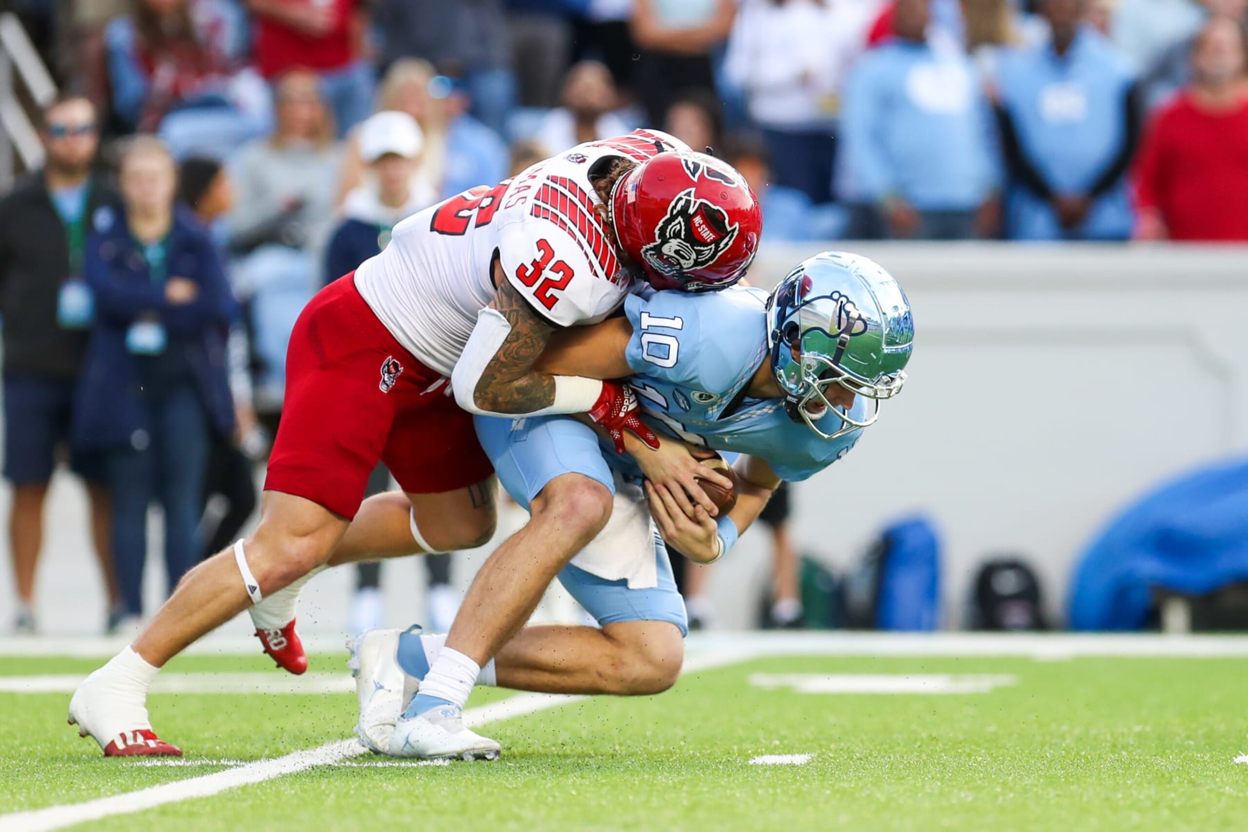 CHAPEL HILL, NC - NOVEMBER 25: Drake Thomas (32) of the North Carolina State Wolfpack sacks Drake Maye (10) of the North Carolina Tar Heels during a football game between the North Carolina Tar Heels and the North Carolina State Wolfpack on Nov 25, 2022 at Kenan Memorial Stadium in Chapel Hill, NC. (Photo by David Jensen/Icon Sportswire via Getty Images)