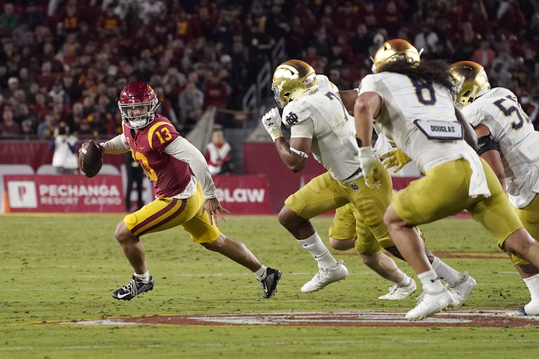 Southern California quarterback Caleb Williams, left, is chase by members of Notre Dame during the first half of an NCAA college football game Saturday, Nov. 26, 2022, in Los Angeles. (AP Photo/Mark J. Terrill)