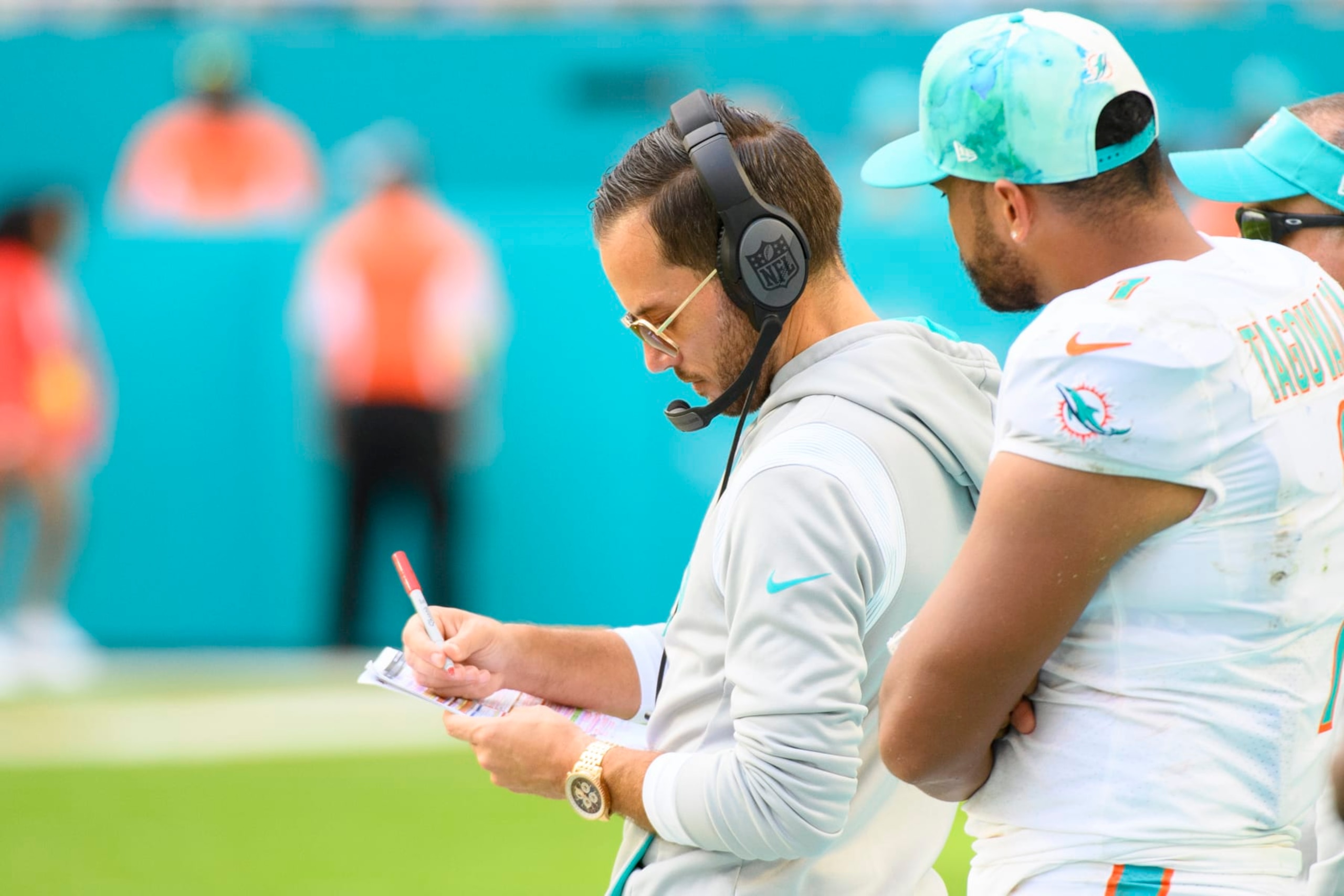 Miami Dolphins quarterback Tua Tagovailoa (1) watches Miami Dolphins head coach Mike McDaniel make notes on the sidelines during an NFL football game between the Houston Texans and the Miami Dolphins, Sunday, Nov. 27, 2022, in Miami Gardens, Fla. (AP Photo/Doug Murray) Miami Dolphins quarterback Tua Tagovailoa (1) watches Miami Dolphins head coach Mike McDaniel make notes on the sidelines during an NFL football game between the Houston Texans and the Miami Dolphins, Sunday, Nov. 27, 2022, in Miami Gardens, Fla. (AP Photo/Doug Murray)