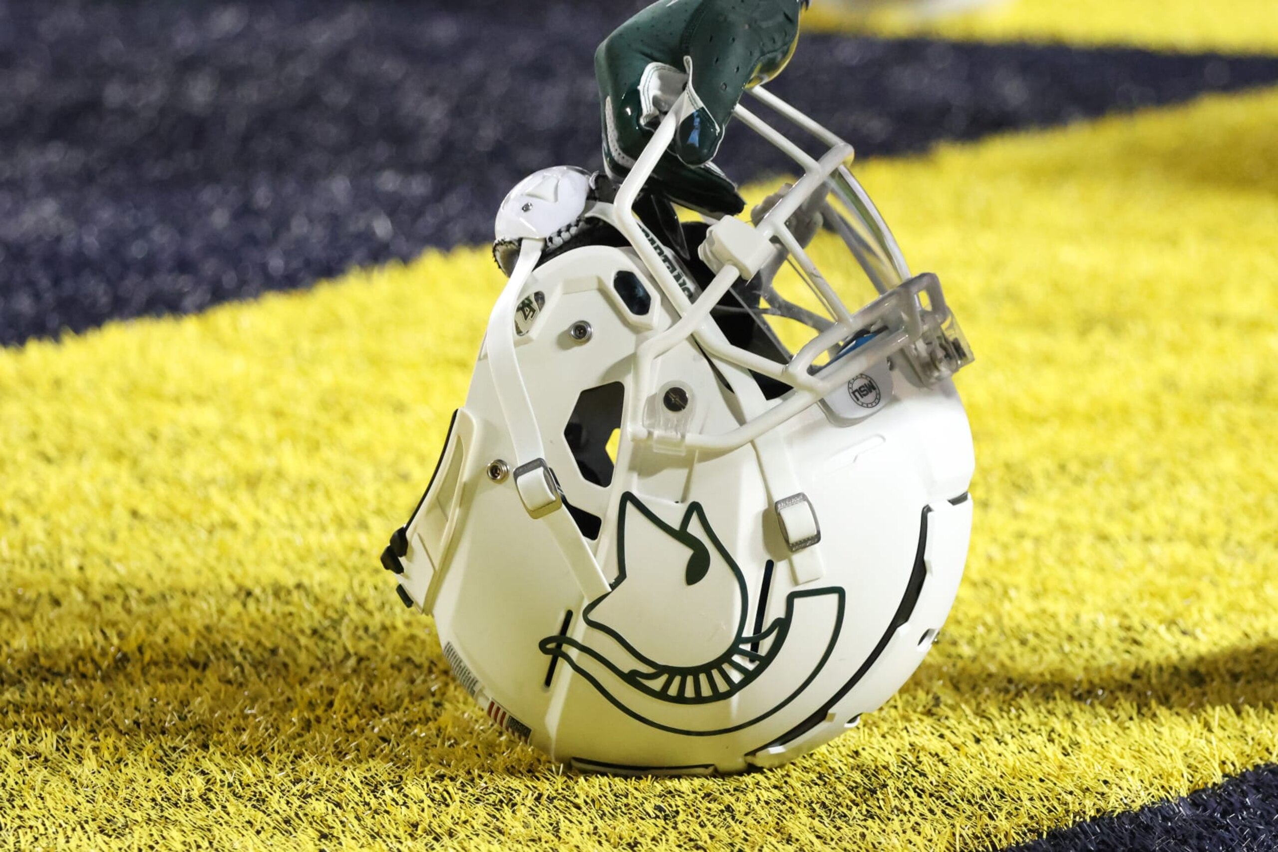 ANN ARBOR, MI - OCTOBER 29:   A general view of the Michigan State helmet is seen as a player kneels in the end zone with his hand on his helmet before the start of a college football game between the Michigan State Spartans and the Michigan Wolverines on October 29, 2022 at Michigan Stadium in Ann Arbor, Michigan.  (Photo by Scott W. Grau/Icon Sportswire via Getty Images)