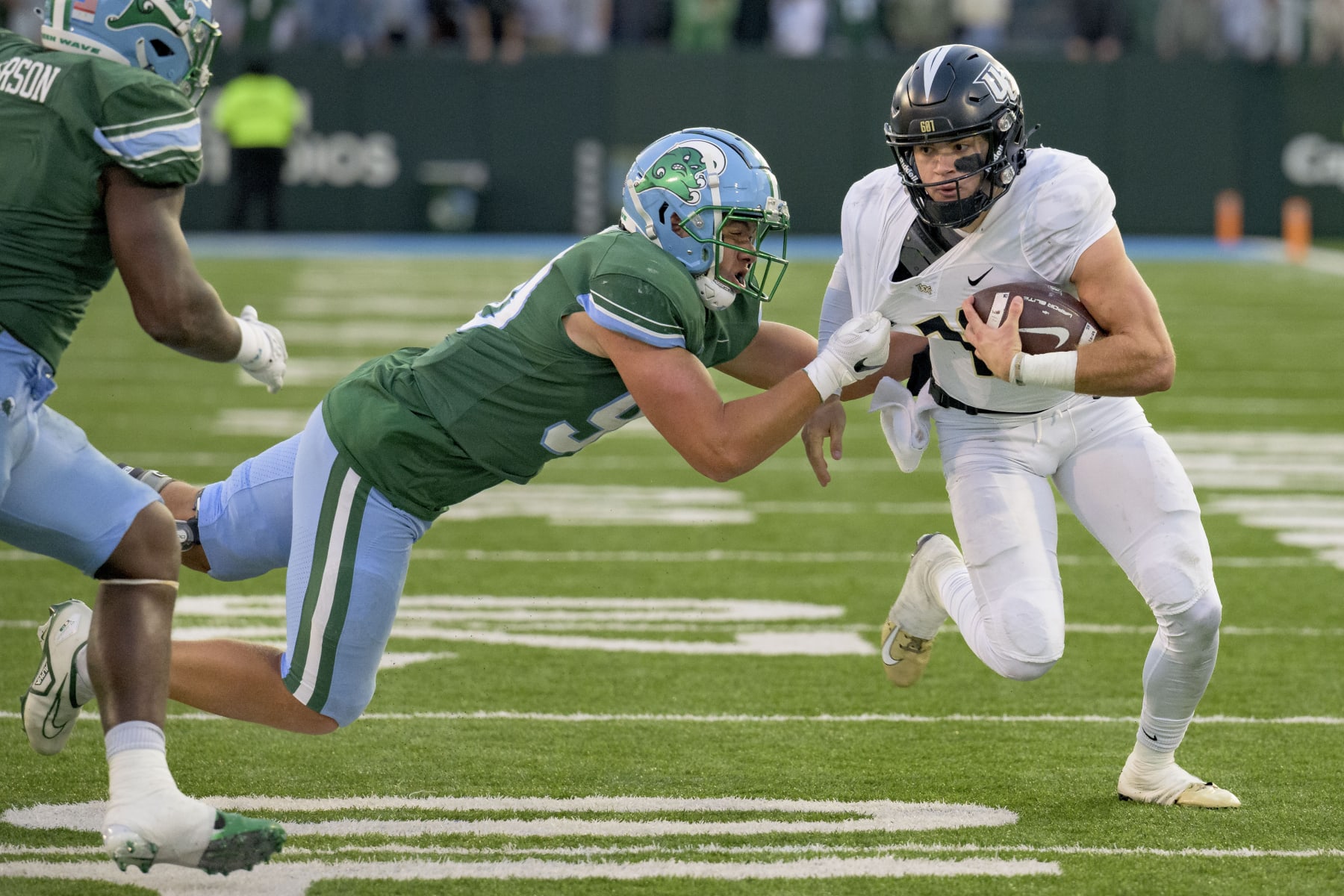 UCF quarterback John Rhys Plumlee tries to get past Tulane linebacker Devean Deal.