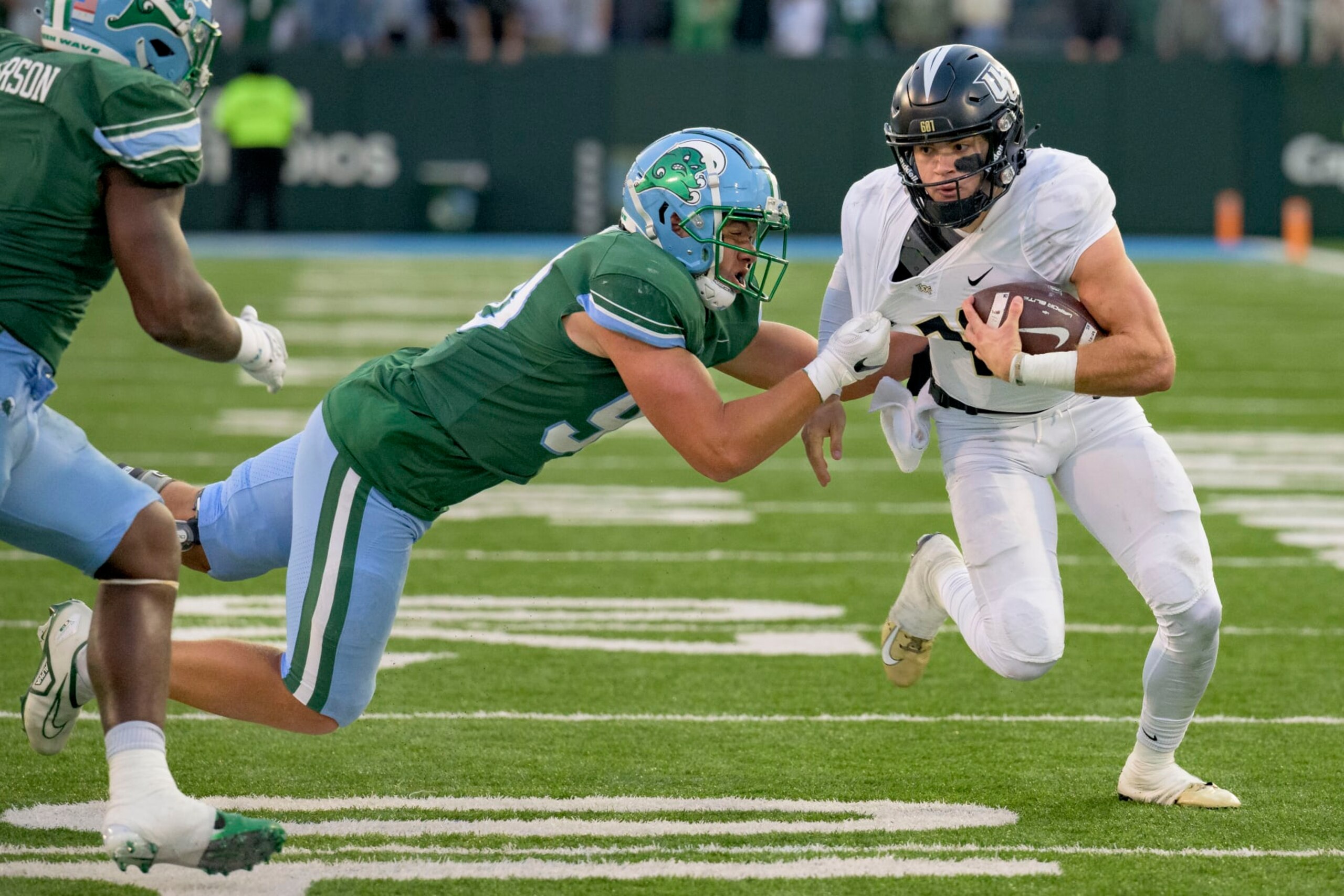 UCF quarterback John Rhys Plumlee tries to get past Tulane linebacker Devean Deal.