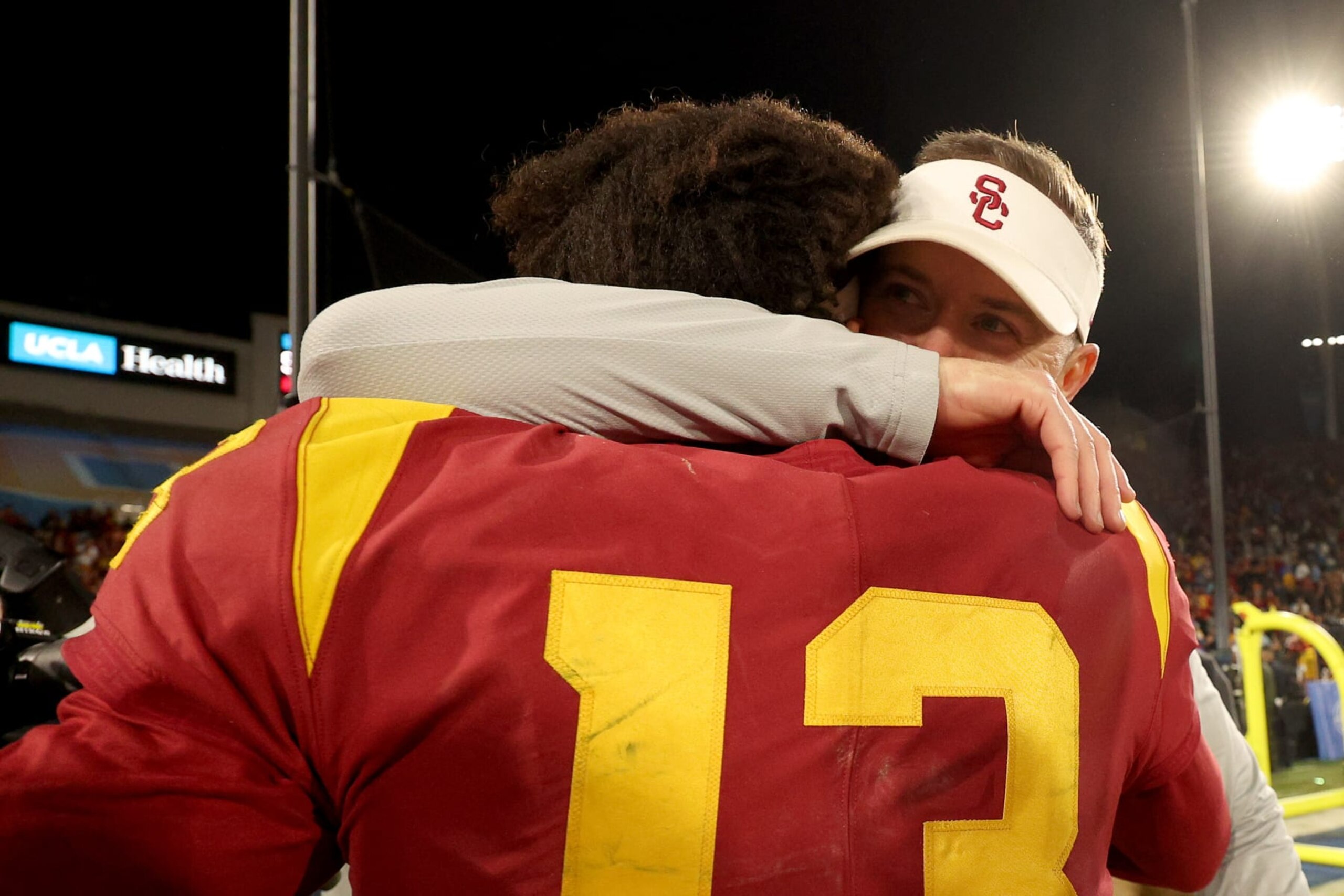 PASADENA, CALIFORNIA - NOVEMBER 19: Head coach Lincoln Riley of the USC Trojans hugs Caleb Williams #13 of the USC Trojans after defeating the UCLA Bruins in the game at Rose Bowl on November 19, 2022 in Pasadena, California. The USC Trojans defeated the UCLA Bruins with a score of 48 to 45. (Photo by Harry How/Getty Images)