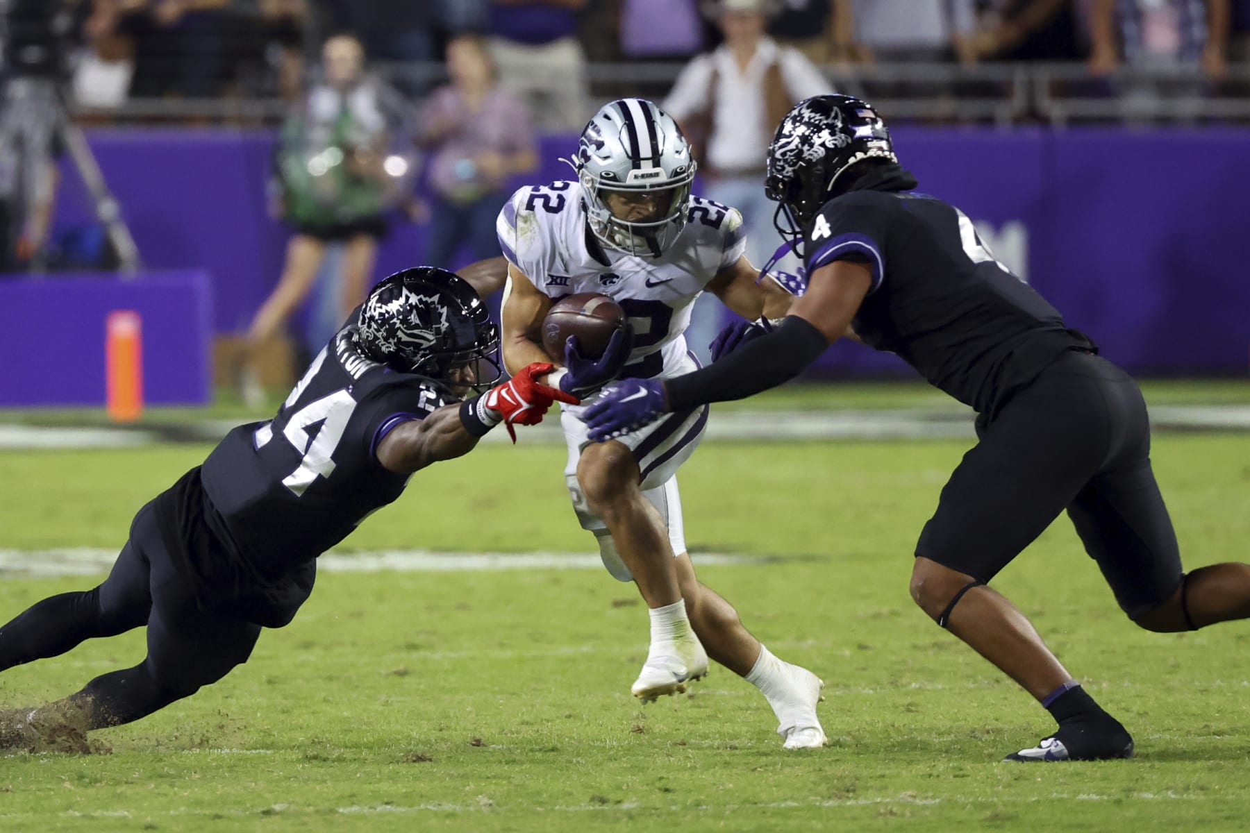 TCU cornerback Josh Newton (24) and safety Namdi Obiazor (4) try to stop Kansas State running back Deuce Vaughn (22) during the second half of an NCAA college football game Saturday, Oct. 22, 2022, in Fort Worth, Texas. (AP Photo/Richard W. Rodriguez)