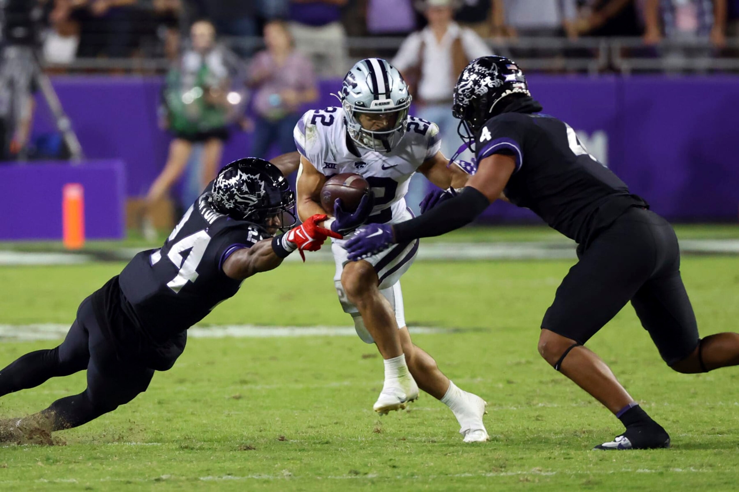 TCU cornerback Josh Newton (24) and safety Namdi Obiazor (4) try to stop Kansas State running back Deuce Vaughn (22) during the second half of an NCAA college football game Saturday, Oct. 22, 2022, in Fort Worth, Texas. (AP Photo/Richard W. Rodriguez) TCU cornerback Josh Newton (24) and safety Namdi Obiazor (4) try to stop Kansas State running back Deuce Vaughn (22) during the second half of an NCAA college football game Saturday, Oct. 22, 2022, in Fort Worth, Texas. (AP Photo/Richard W. Rodriguez)