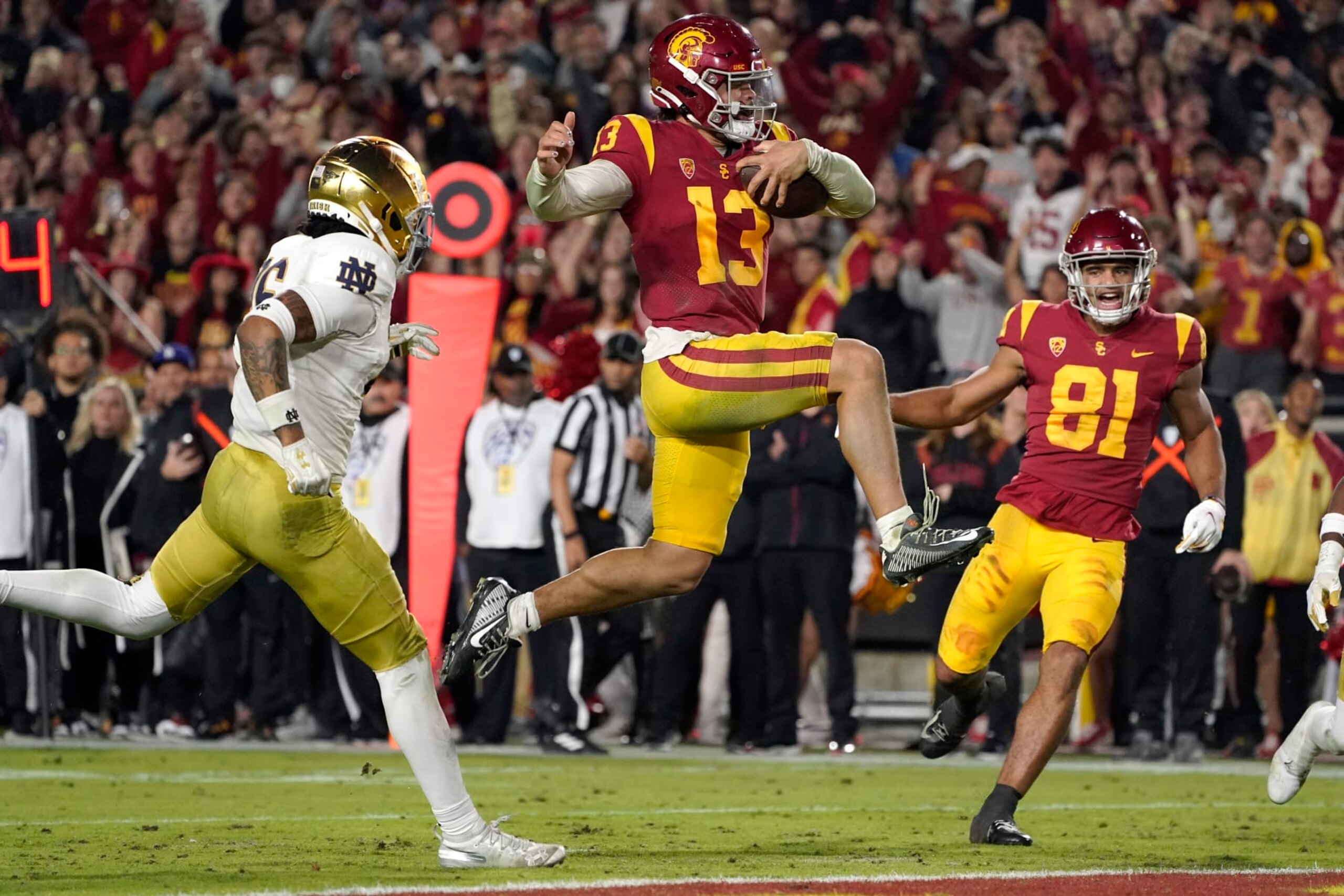 CORRECTS TO SECOND HALF, INSTEAD OF FIRST - Southern California quarterback Caleb Williams jumps in for a touchdown as Notre Dame safety Xavier Watts, left, defends and Southern California wide receiver Kyle Ford watches during the second half of an NCAA college football game Saturday, Nov. 26, 2022, in Los Angeles. (AP Photo/Mark J. Terrill) CORRECTS TO SECOND HALF, INSTEAD OF FIRST - Southern California quarterback Caleb Williams jumps in for a touchdown as Notre Dame safety Xavier Watts, left, defends and Southern California wide receiver Kyle Ford watches during the second half of an NCAA college football game Saturday, Nov. 26, 2022, in Los Angeles. (AP Photo/Mark J. Terrill)