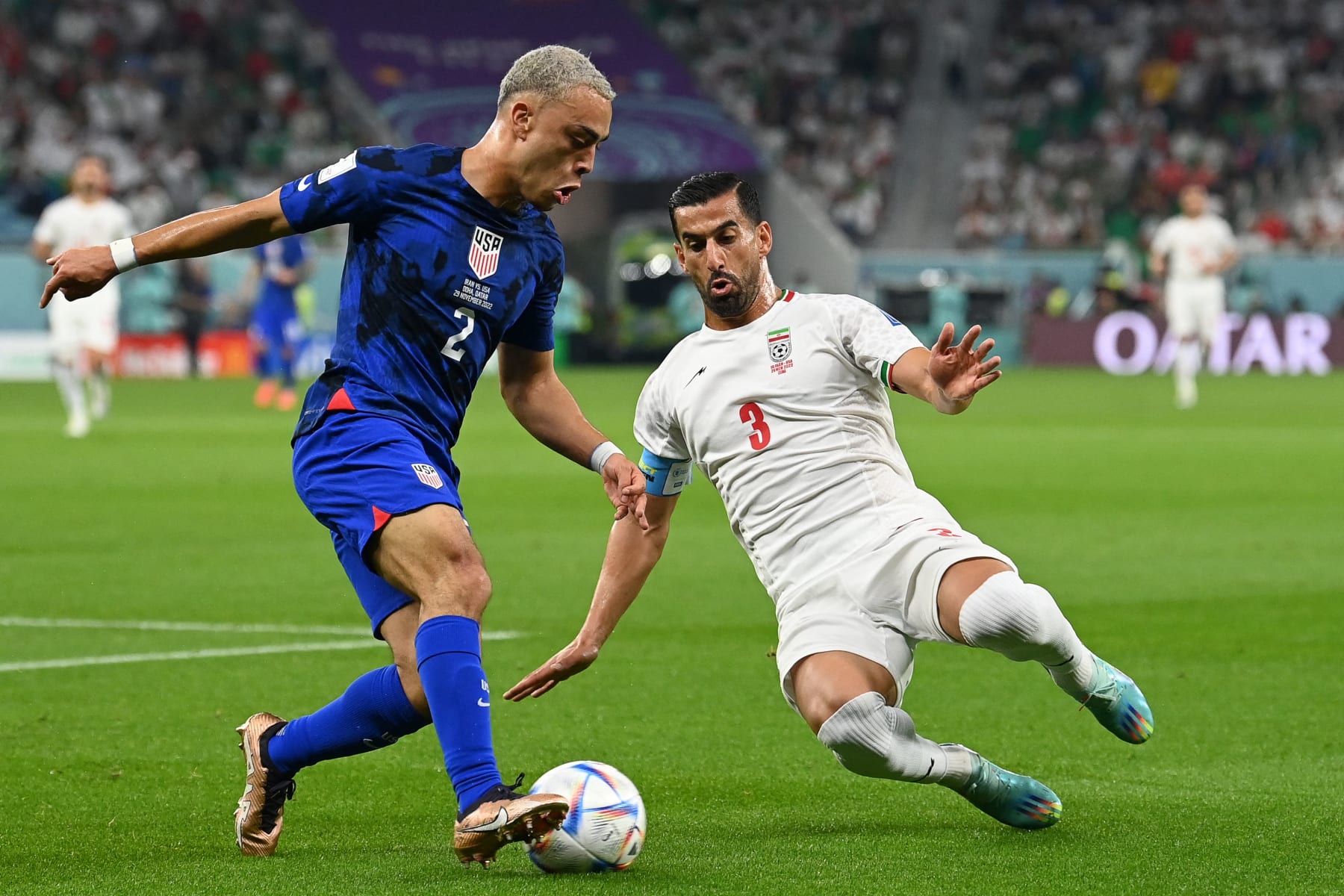 USA's defender #02 Sergino Dest fights for the ball with Iran's defender #03 Ehsan Hajsafi  during the Qatar 2022 World Cup Group B football match between Iran and USA at the Al-Thumama Stadium in Doha on November 29, 2022. (Photo by Glyn KIRK / AFP) (Photo by GLYN KIRK/AFP via Getty Images)