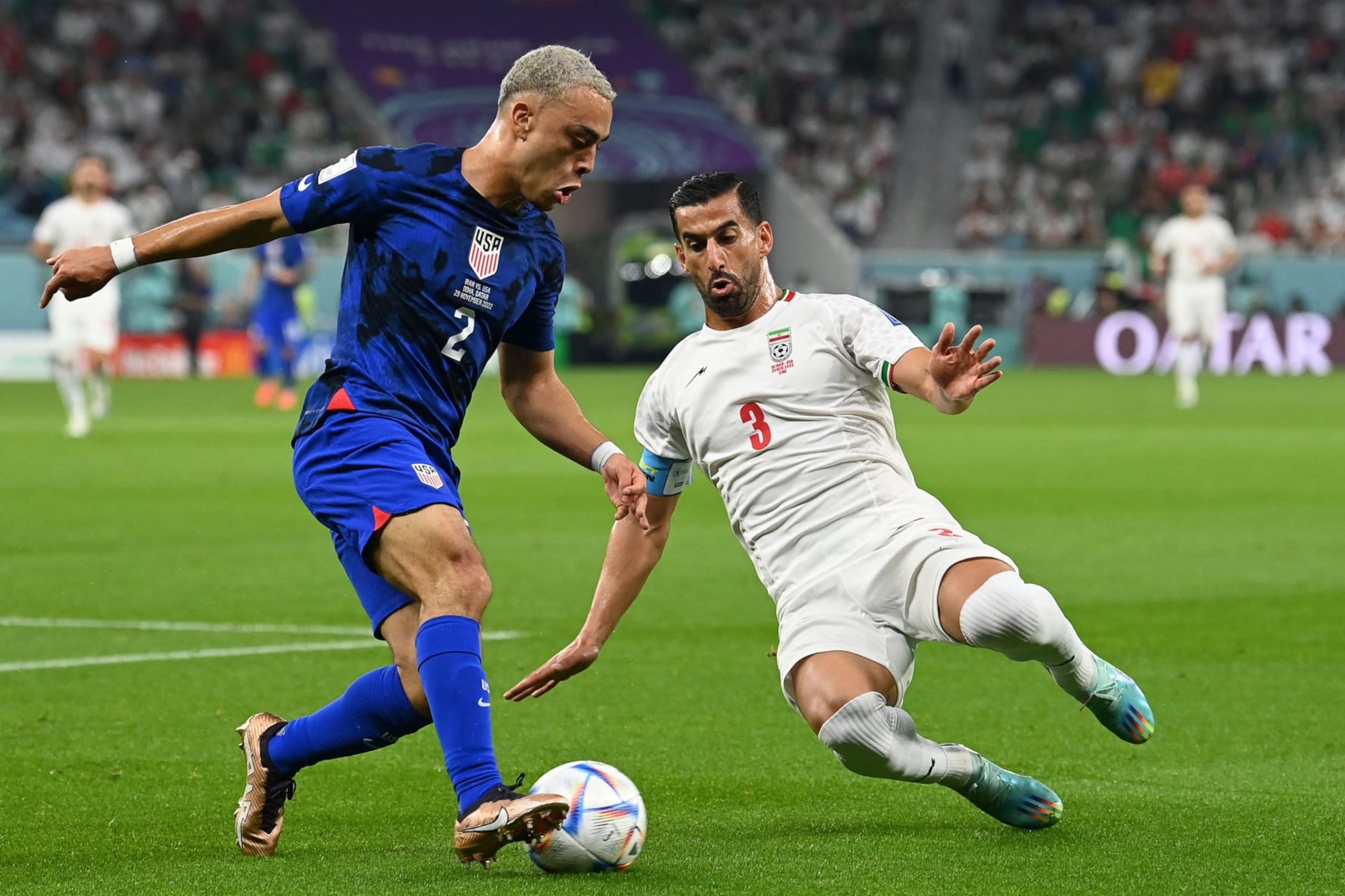 USA's defender #02 Sergino Dest fights for the ball with Iran's defender #03 Ehsan Hajsafi  during the Qatar 2022 World Cup Group B football match between Iran and USA at the Al-Thumama Stadium in Doha on November 29, 2022. (Photo by Glyn KIRK / AFP) (Photo by GLYN KIRK/AFP via Getty Images)