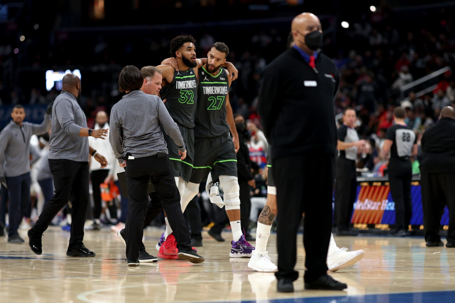 WASHINGTON, DC - NOVEMBER 28: Karl-Anthony Towns #32 of the Minnesota Timberwolves is helped off the court by teammate Rudy Gobert #27 after being injured in the third quarter against the Washington Wizards at Capital One Arena on November 28, 2022 in Washington, DC. NOTE TO USER: User expressly acknowledges and agrees that, by downloading and or using this photograph, User is consenting to the terms and conditions of the Getty Images License Agreement. (Photo by Rob Carr/Getty Images)