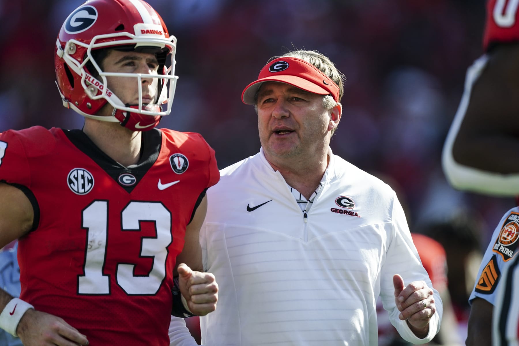 Georgia head coach Kirby Smart runs off the field with quarterback Stetson Bennett after the first half of an NCAA college football game Saturday, Nov. 26, 2022 in Athens, Ga. (AP Photo/John Bazemore)