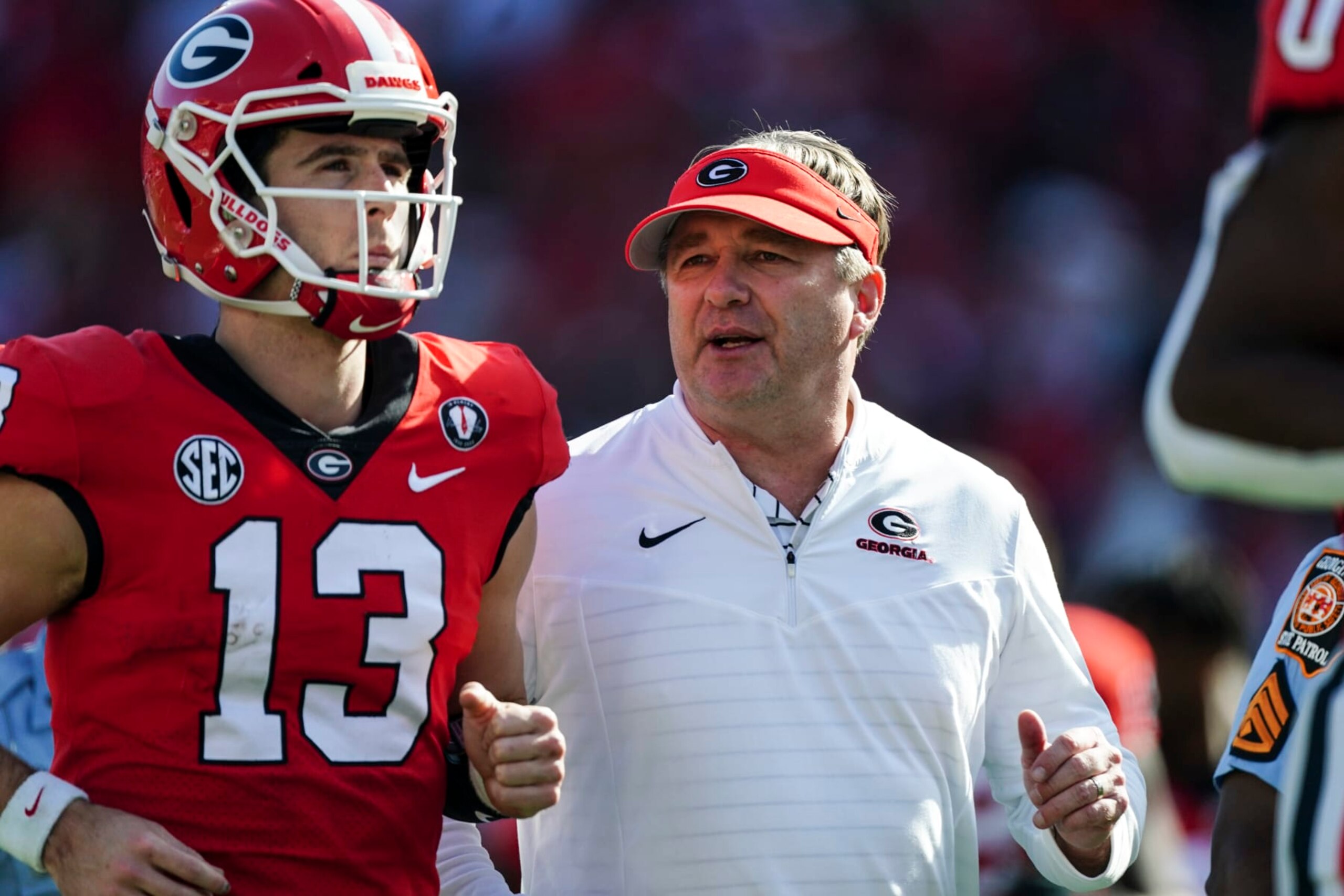 Georgia head coach Kirby Smart runs off the field with quarterback Stetson Bennett after the first half of an NCAA college football game Saturday, Nov. 26, 2022 in Athens, Ga. (AP Photo/John Bazemore)