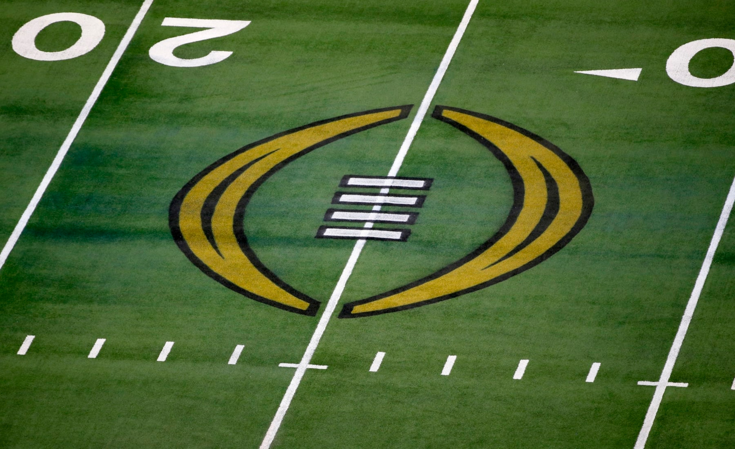 FILE - The College Football Playoff logo is shown on the field at AT&T Stadium before an NCAA college football game in Arlington, Texas, Jan. 1, 2021. The College Football Playoff is set to remain a four-team format through the 2025 season after the administrators who manage the postseason failed to agree on an expansion plan before the current contracts run out. A person involved with the decision told The Associated Press on Friday, Feb. 18, 2022, that the CFP management committee, comprised of 10 conference commissioners and Notre Dame’s athletic director, met by video conference earlier this week. (AP Photo/Roger Steinman, File)