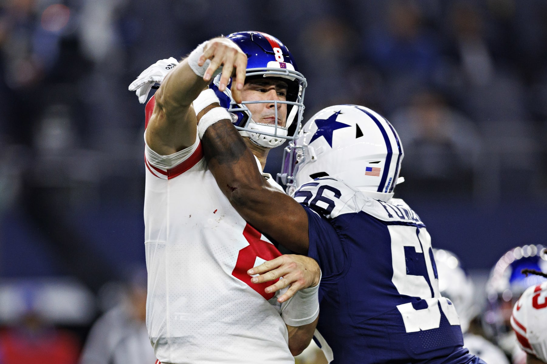ARLINGTON, TEXAS - NOVEMBER 24:  Daniel Jones #8 of the New York Giants throws a pass under pressure from Dante Fowler #56 of the Dallas Cowboys at AT&T Stadium on November 24, 2022 in Arlington, Texas. The Cowboys defeated the Giants 28-20. (Photo by Wesley Hitt/Getty Images)