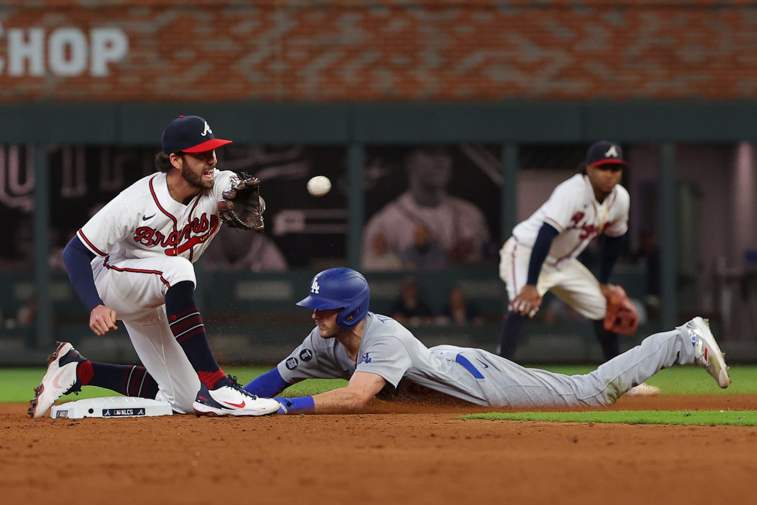 ATLANTA, GEORGIA - OCTOBER 16: Trea Turner #6 of the Los Angeles Dodgers safely steals second base past the tag of Dansby Swanson #7 of the Atlanta Braves during the fifth inning of Game One of the National League Championship Series at Truist Park on October 16, 2021 in Atlanta, Georgia. (Photo by Kevin C. Cox/Getty Images)