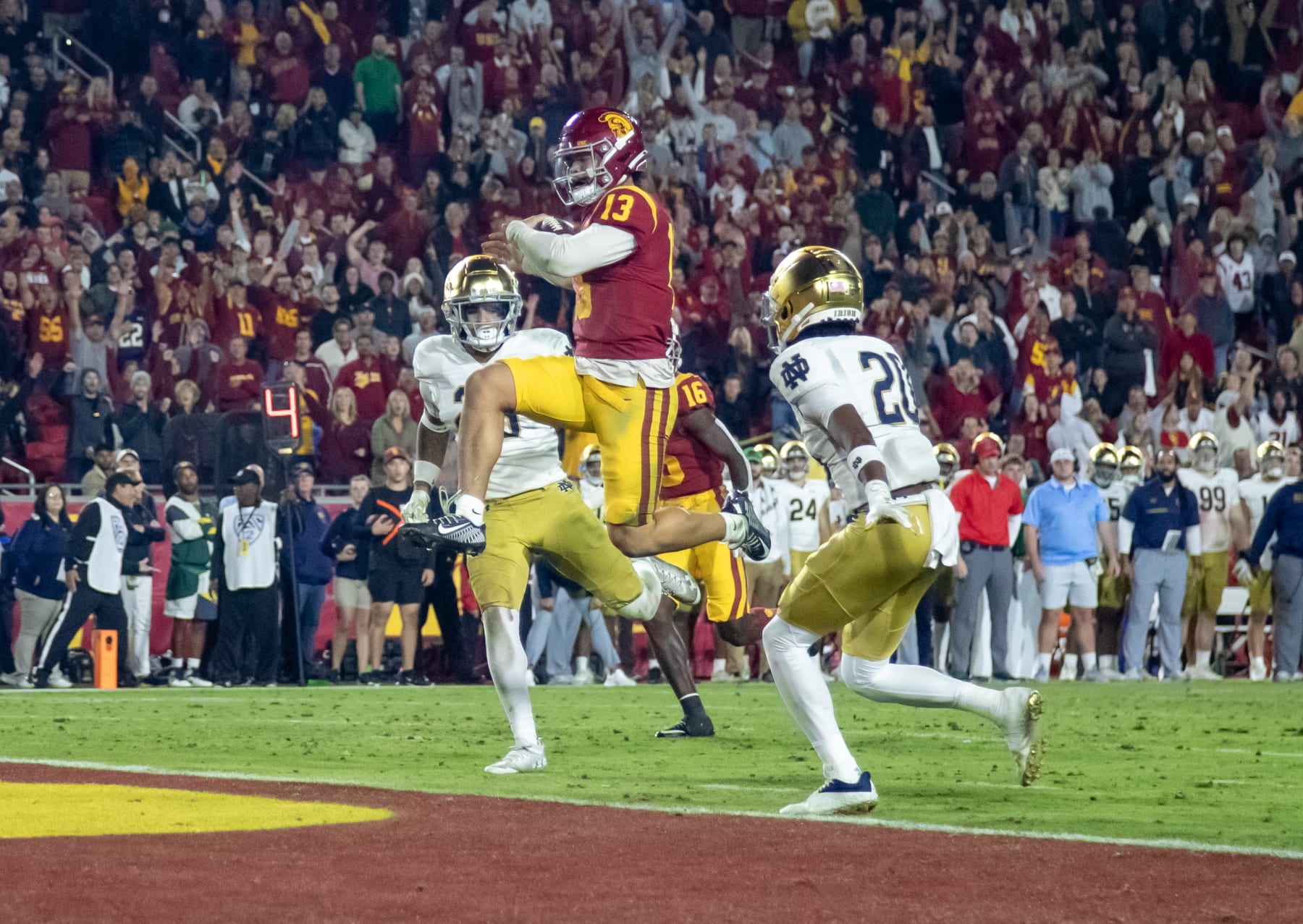 LOS ANGELES, CA - NOVEMBER 26, 2022: USC Trojans quarterback Caleb Williams (13) scores his third touchdown of the game against Notre Dame Fighting Irish safety Xavier Watts (26) and Notre Dame Fighting Irish cornerback Benjamin Morrison (20) in the fourth quarter at the Coliseum on November 26, 2022 in Los Angeles, California.(Gina Ferazzi / Los Angeles Times via Getty Images) LOS ANGELES, CA - NOVEMBER 26, 2022: USC Trojans quarterback Caleb Williams (13) scores his third touchdown of the game against Notre Dame Fighting Irish safety Xavier Watts (26) and Notre Dame Fighting Irish cornerback Benjamin Morrison (20) in the fourth quarter at the Coliseum on November 26, 2022 in Los Angeles, California.(Gina Ferazzi / Los Angeles Times via Getty Images)