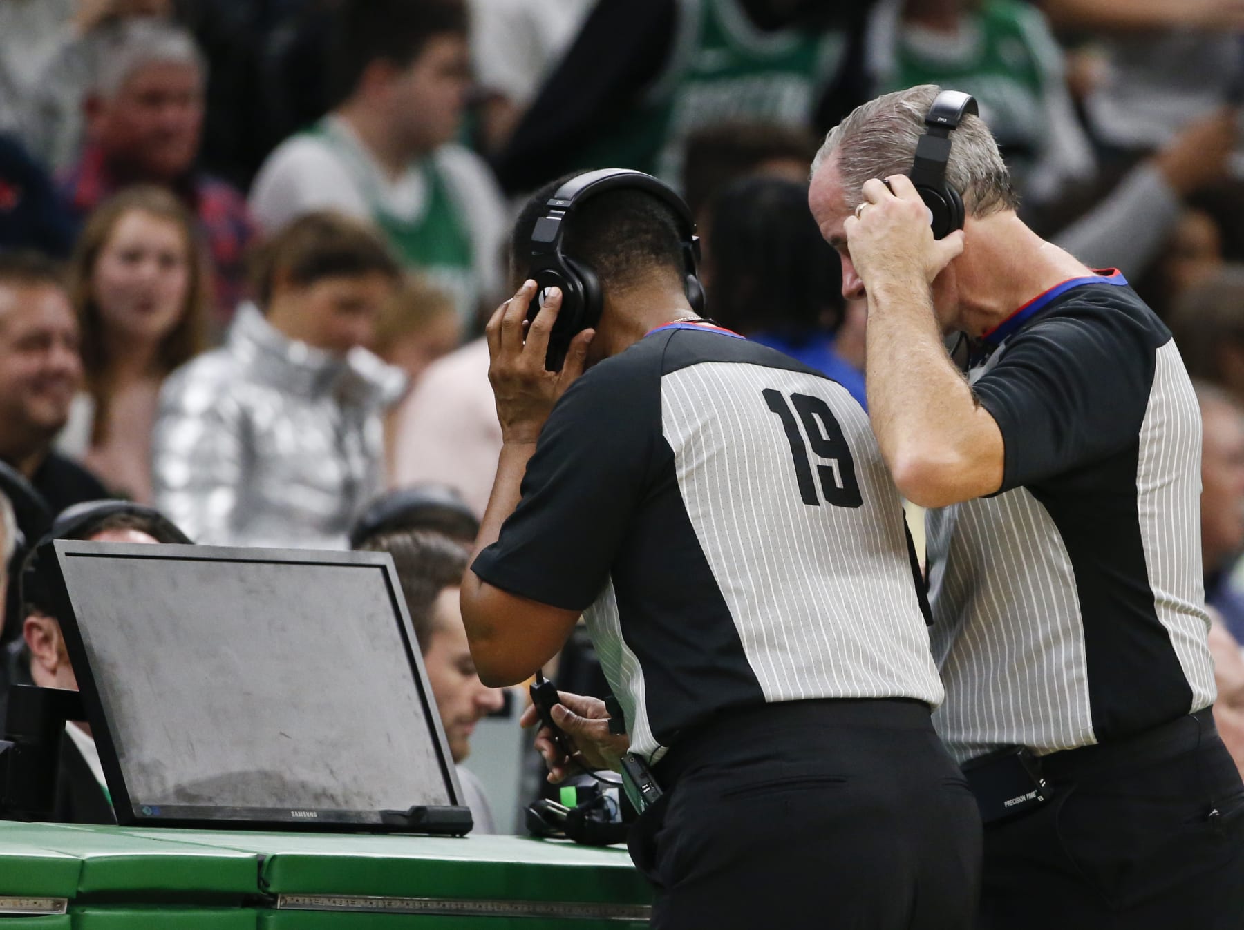 BOSTON - NOVEMBER 27: NBA referees James Capers (19) and Scott Wall look at the replay screen on a blocking call against the Boston Celtics' Jaylen Brown on Brooklyn Nets' Nicolas Claxton during the fourth quarter. After official review, the call was overturned, and Claxton was called for an offensive foul. The Boston Celtics host the Brooklyn Nets in a regular season NBA basketball game at TD Garden in Boston on Nov. 27, 2019. (Photo by Matthew J. Lee/The Boston Globe via Getty Images)
