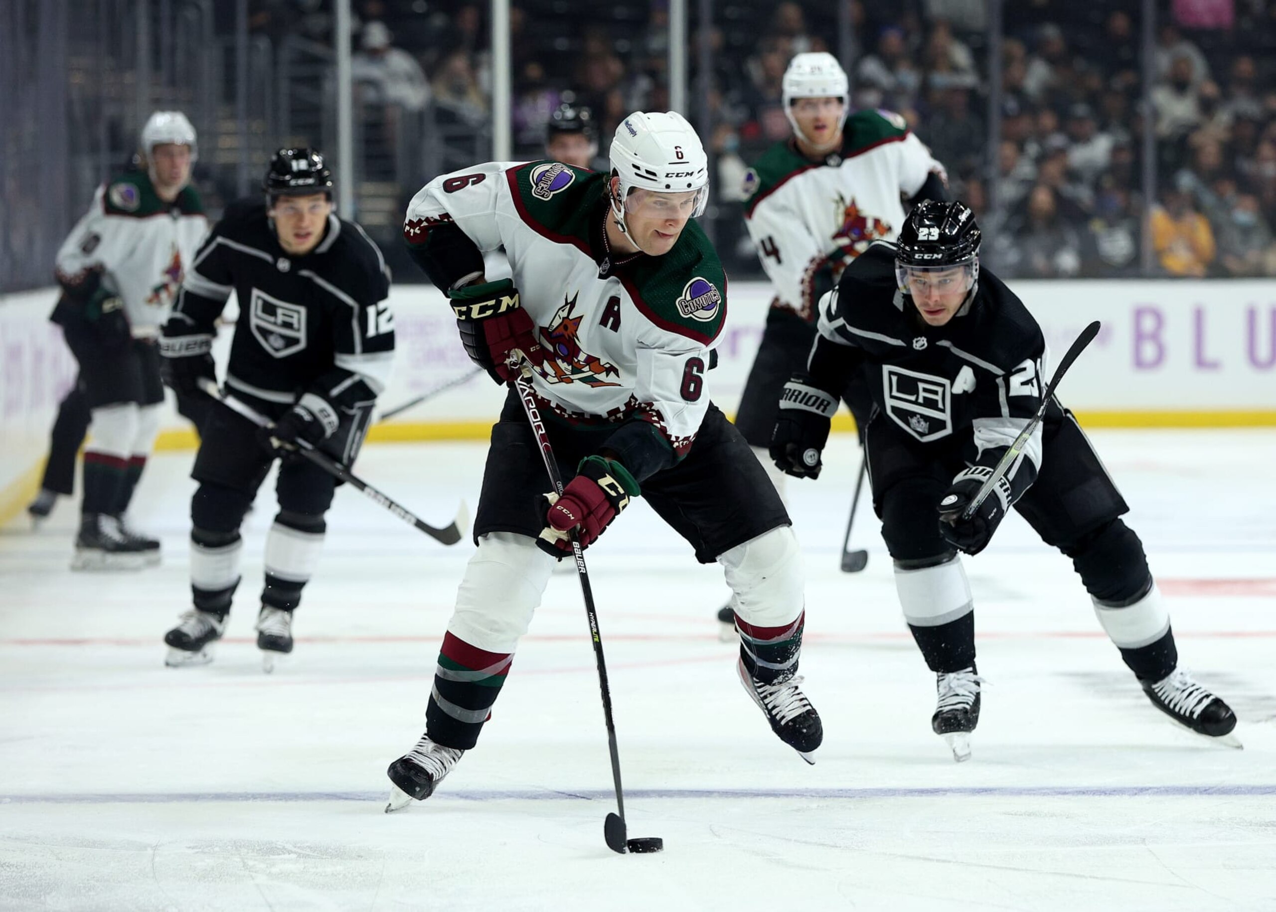 LOS ANGELES, CALIFORNIA - NOVEMBER 21: Jakob Chychrun #6 of the Arizona Coyotes skates with the puck as he is chased by Dustin Brown #23 of the Los Angeles Kings during the third period in a 2-1 Coyotes overtime win at Staples Center on November 21, 2021 in Los Angeles, California. (Photo by Harry How/Getty Images)