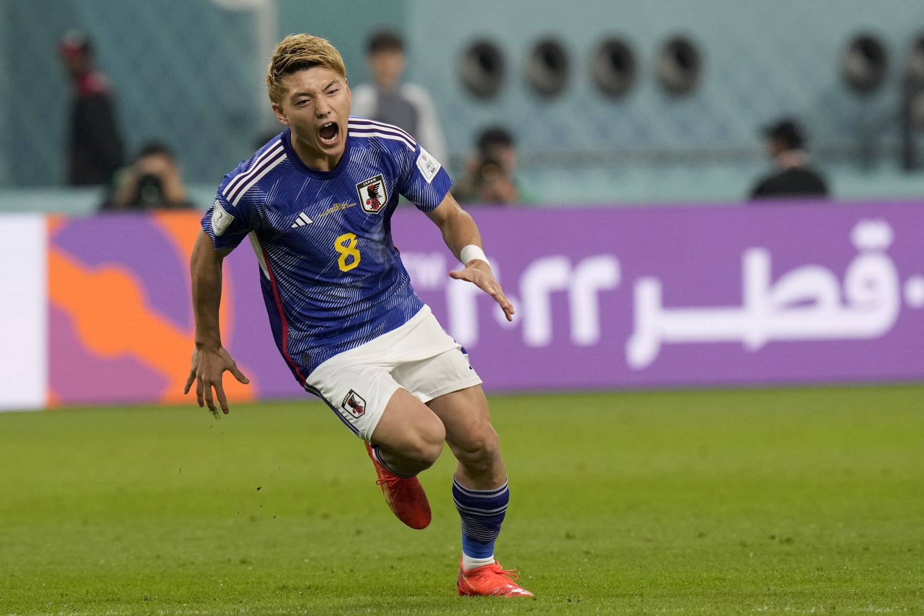 Japan's Ritsu Doan celebrates scoring his side's first goal during a World Cup group E soccer match at the Khalifa International Stadium in Doha, Qatar, Thursday, Dec. 1, 2022. (AP Photo/Eugene Hoshiko)