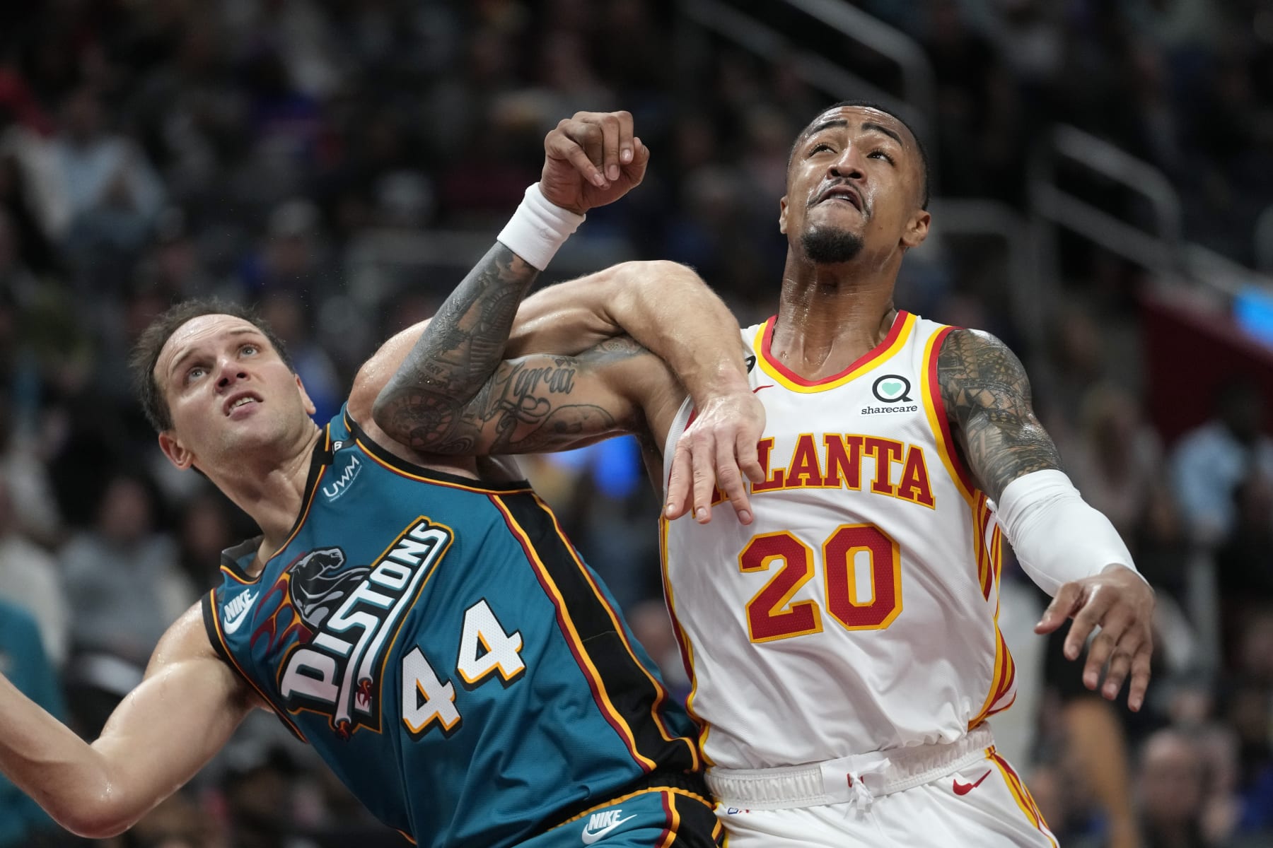 Detroit Pistons forward Bojan Bogdanovic (44) and Atlanta Hawks forward John Collins (20) battle for position in the second half of an NBA basketball game in Detroit, Friday, Oct. 28, 2022. (AP Photo/Paul Sancya)