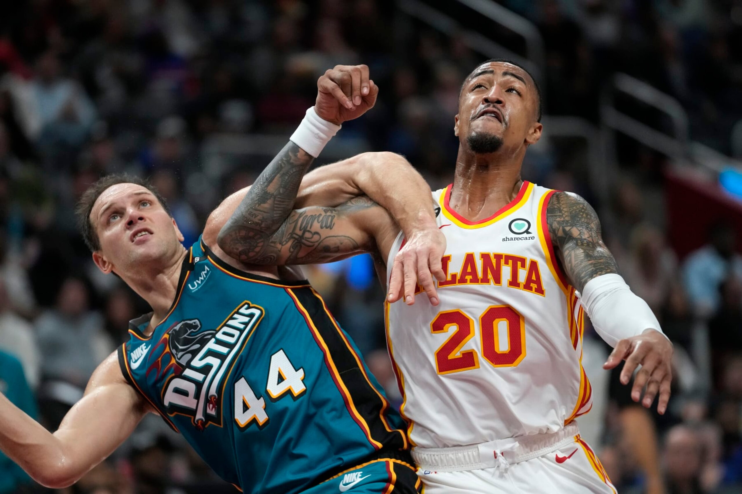 Detroit Pistons forward Bojan Bogdanovic (44) and Atlanta Hawks forward John Collins (20) battle for position in the second half of an NBA basketball game in Detroit, Friday, Oct. 28, 2022. (AP Photo/Paul Sancya)