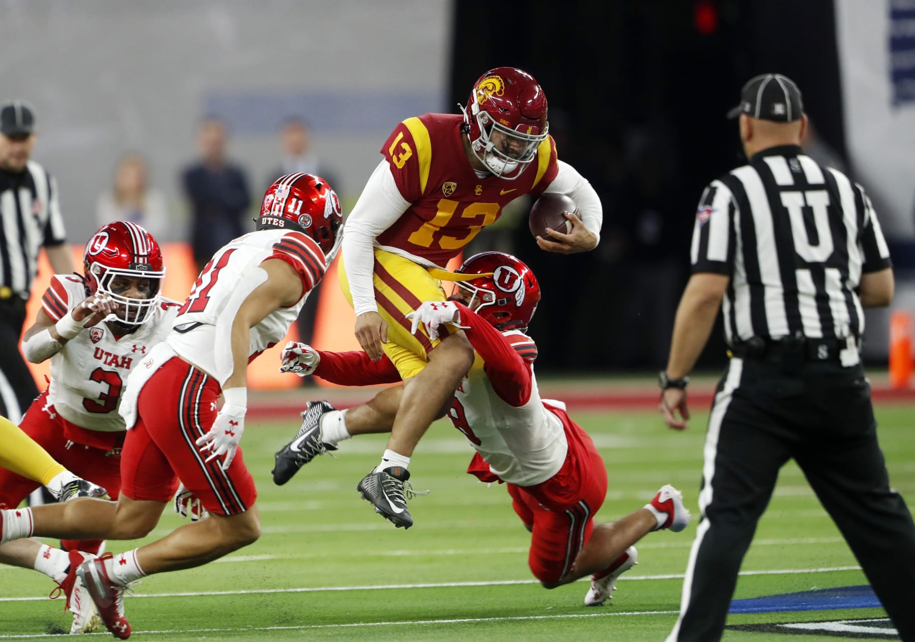 Southern California quarterback Caleb Williams (13) is tackled by Utah safeties R.J. Hubert (11) and Cole Bishop (8) during the first half of the Pac-12 Conference championship NCAA college football game Friday, Dec. 2, 2022, in Las Vegas. (AP Photo/Steve Marcus)