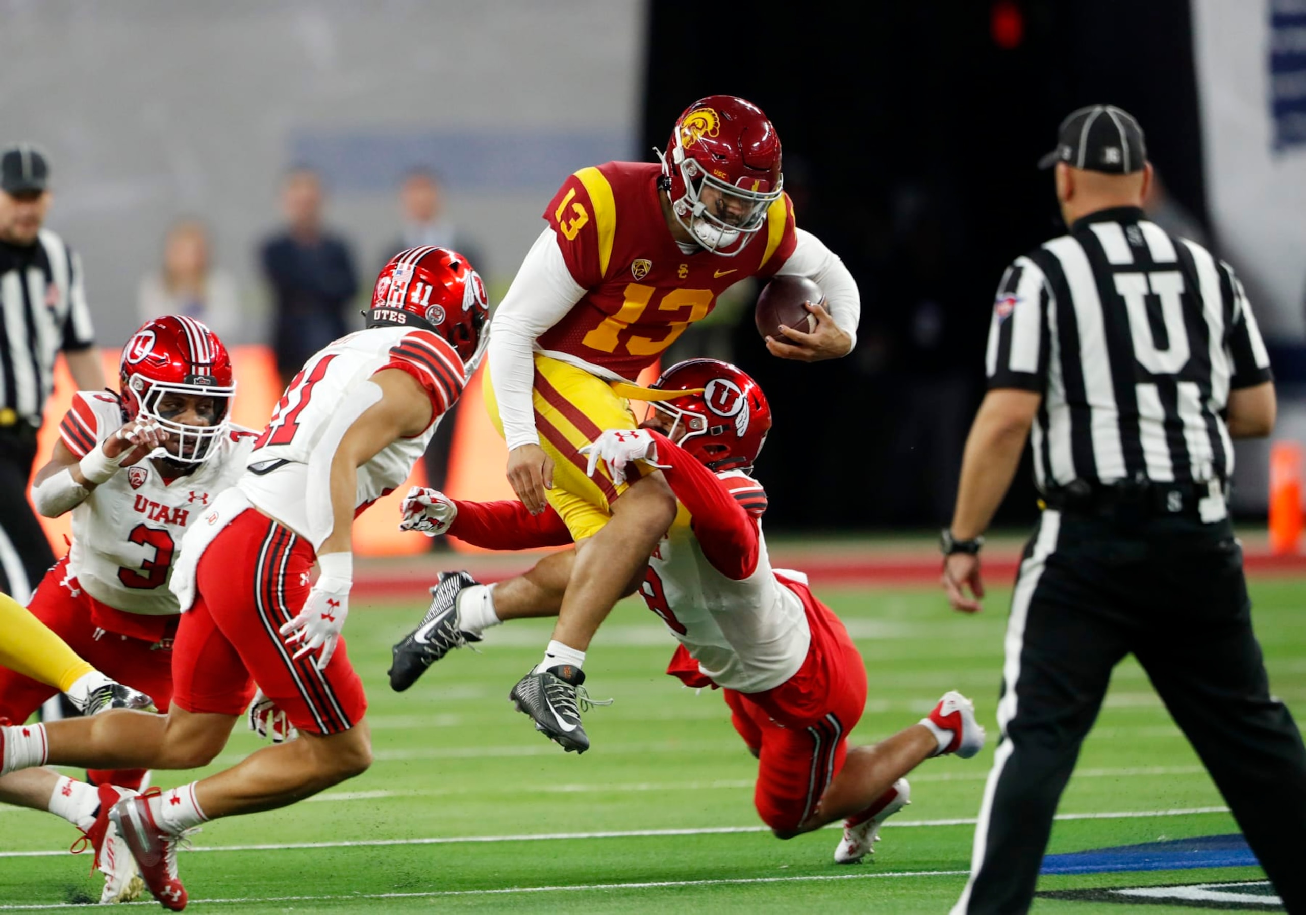 Southern California quarterback Caleb Williams (13) is tackled by Utah safeties R.J. Hubert (11) and Cole Bishop (8) during the first half of the Pac-12 Conference championship NCAA college football game Friday, Dec. 2, 2022, in Las Vegas. (AP Photo/Steve Marcus)