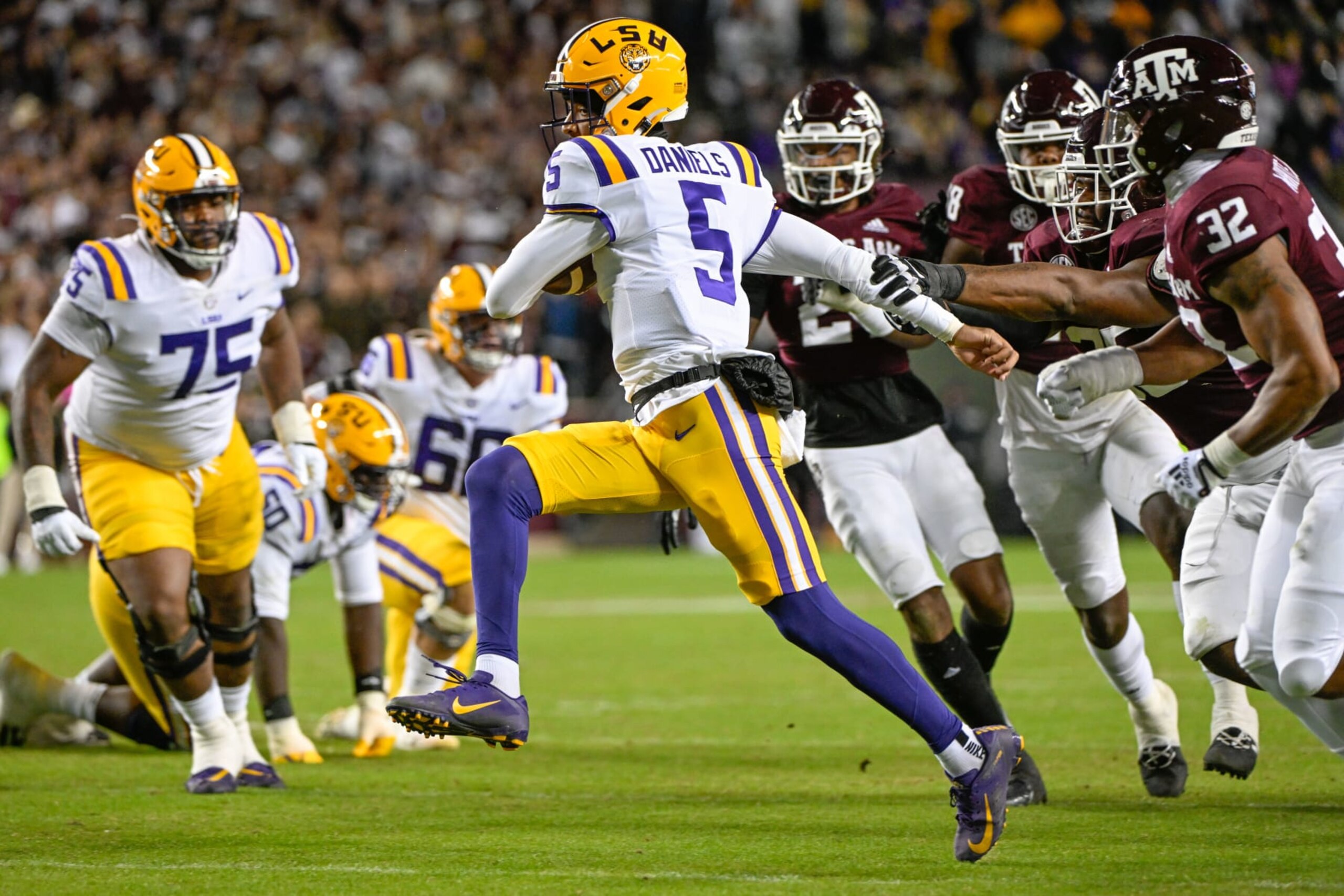 COLLEGE STATION, TX - NOVEMBER 26: LSU Tigers quarterback Jayden Daniels (5) is flushed from the pocket as four Aggies give chase during the football game between the LSU Tigers and Texas A&M Aggies at Kyle Field on November 26, 2022 in College Station, Texas. (Photo by Ken Murray/Icon Sportswire via Getty Images)