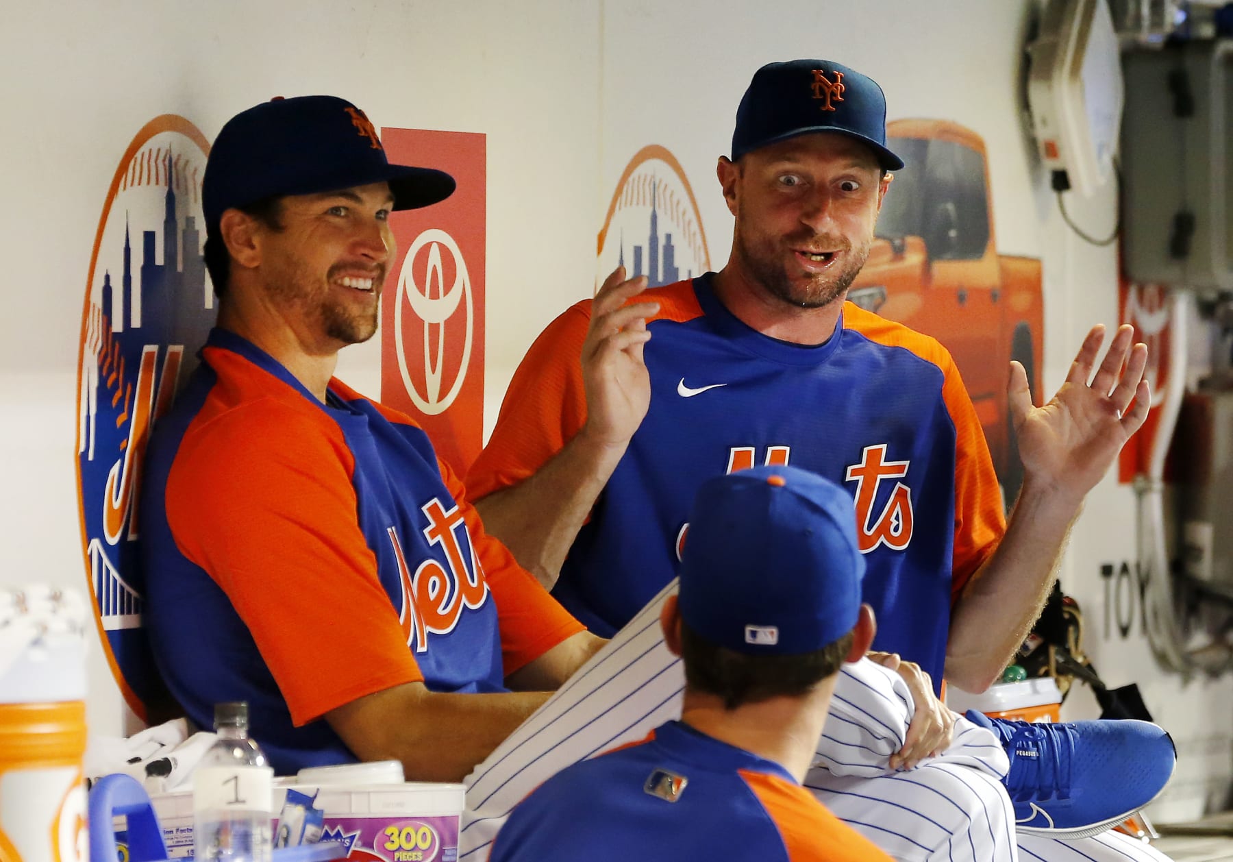 NEW YORK, NEW YORK - AUGUST 04:  Jacob deGrom #48 (L) and Max Scherzer #21 of the New York Mets talk in the dugout during a game against the Atlanta Braves at Citi Field on August 04, 2022 in New York City. The Mets defeated the Braves 6-4. (Photo by Jim McIsaac/Getty Images)