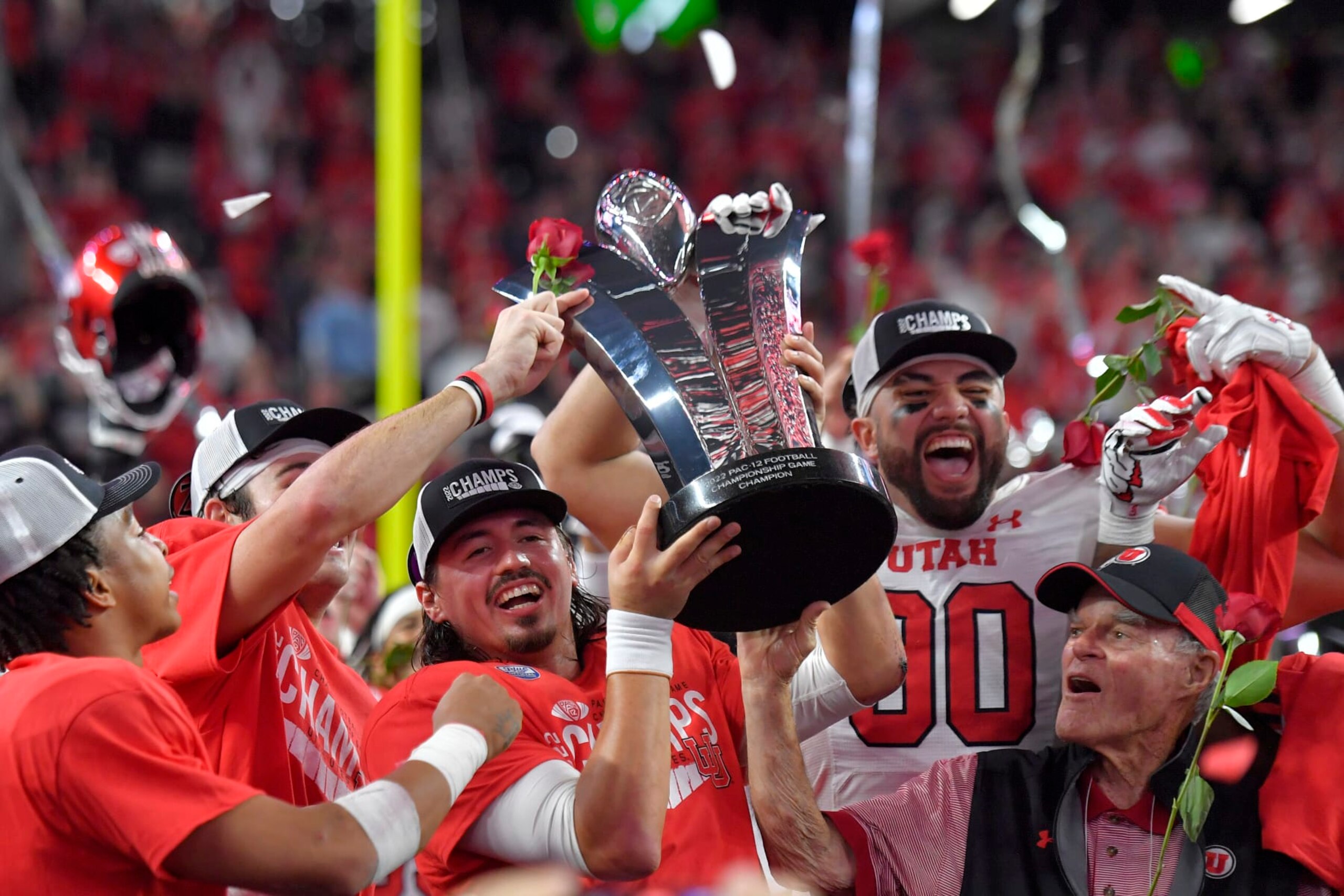 LAS VEGAS, NEVADA - DECEMBER 02: Cameron Rising #7 and Devin Kaufusi #90 of the Utah Utes celebrate with the Schwabacher Trophy after defeating the USC Trojans in the Pac-12 Championship at Allegiant Stadium on December 02, 2022 in Las Vegas, Nevada. (Photo by David Becker/Getty Images)