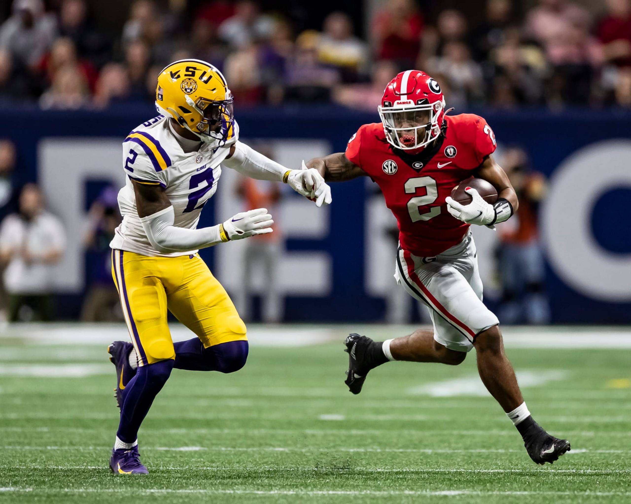 ATLANTA, GA - DECEMBER 3: Kendall Milton #2 of the Georgia Bulldogs tries to evade Mekhi Garner #2 of the LSU Tigers during a game between LSU Tigers and Georgia Bulldogs at Mercedes-Benz Stadium on December 3, 2022 in Atlanta, Georgia. (Photo by Steve Limentani/ISI Photos/Getty Images)