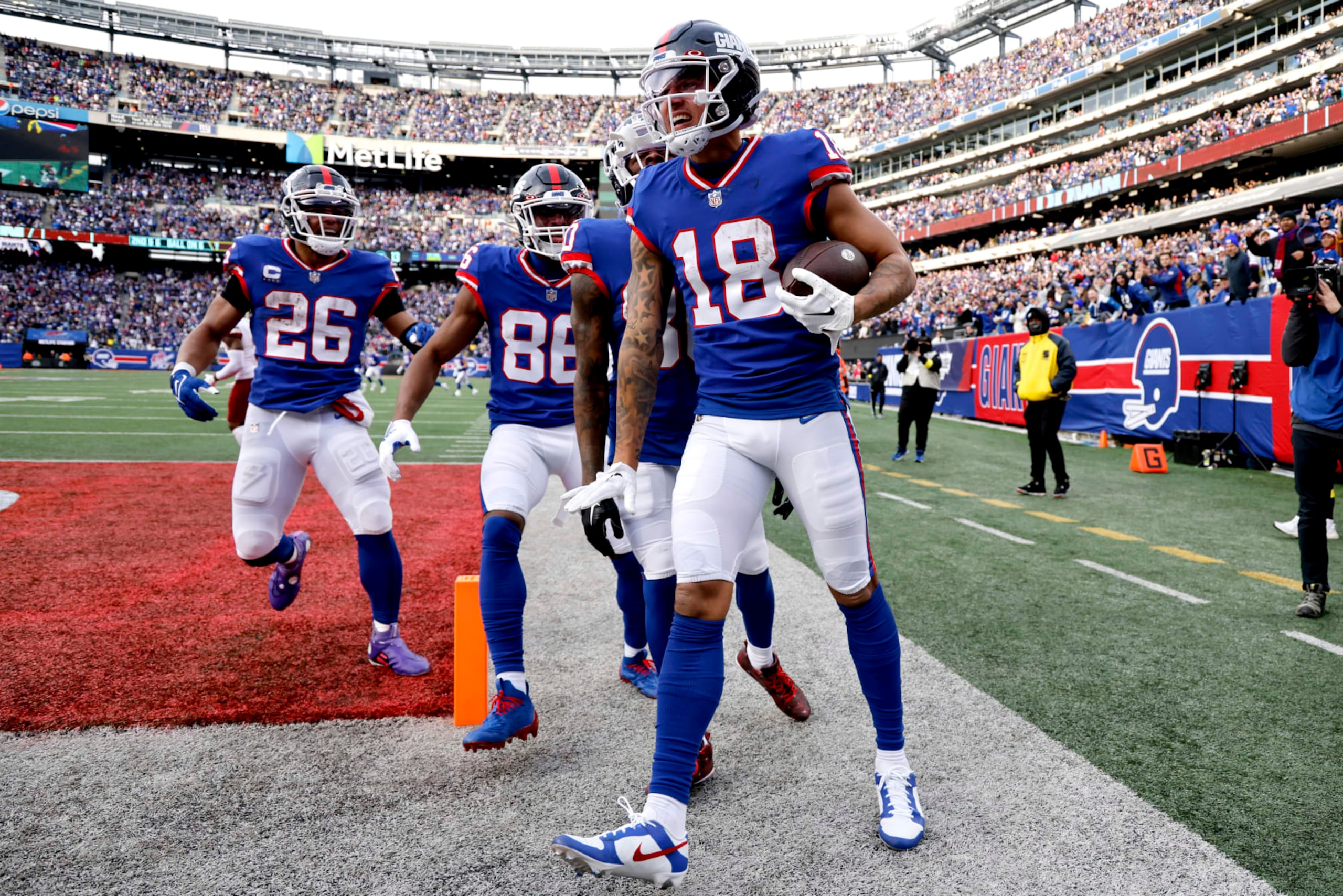 EAST RUTHERFORD, NEW JERSEY - DECEMBER 04: Isaiah Hodgins #18 of the New York Giants celebrates after scoring a touchdown in the third quarter of a game against the Washington Commanders at MetLife Stadium on December 04, 2022 in East Rutherford, New Jersey. (Photo by Al Bello/Getty Images)