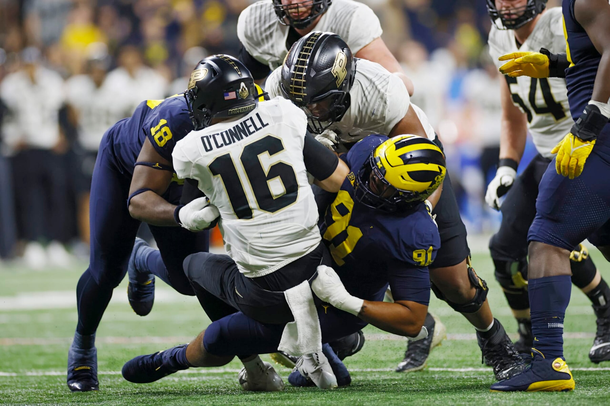 INDIANAPOLIS, IN - DECEMBER 03: Michigan Wolverines linebacker Taylor Upshaw (91) and linebacker Eyabi Okie (18) sack Purdue Boilermakers quarterback Aidan O'Connell (16) during the Big 10 Championship college football game on December 3, 2022 at Lucas Oil Stadium in Indianapolis, Indiana. (Photo by Joe Robbins/Icon Sportswire via Getty Images)