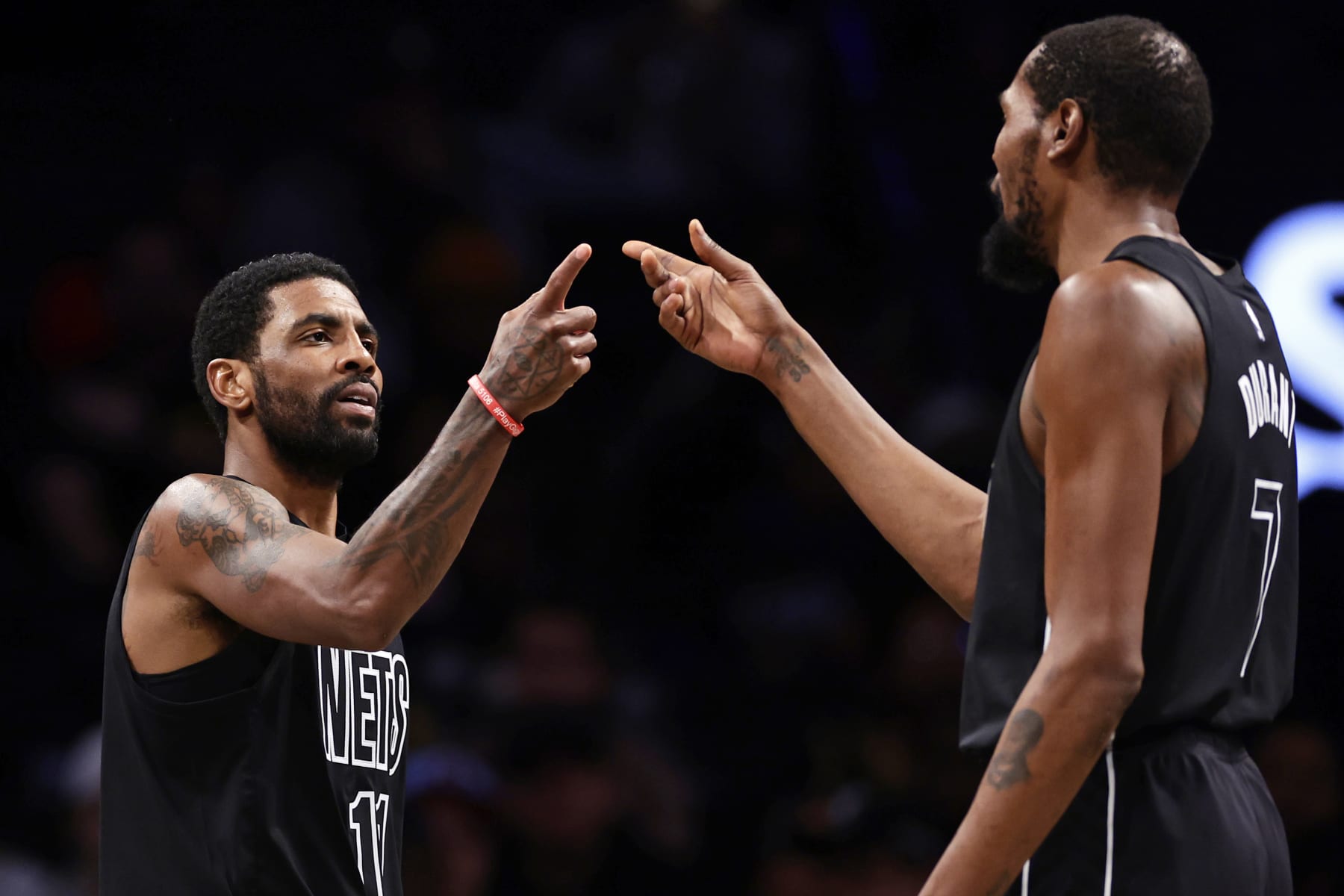 NEW YORK, NEW YORK - DECEMBER 2: Kyrie Irving #11 of the Brooklyn Nets reacts with teammate Kevin Durant #7 against the Toronto Raptors during the second half at Barclays Center on December 2, 2022 in New York City. The Nets won 114-105. NOTE TO USER: User expressly acknowledges and agrees that, by downloading and or using this Photograph, user is consenting to the terms and conditions of the Getty Images License Agreement.  (Photo by Adam Hunger/Getty Images)