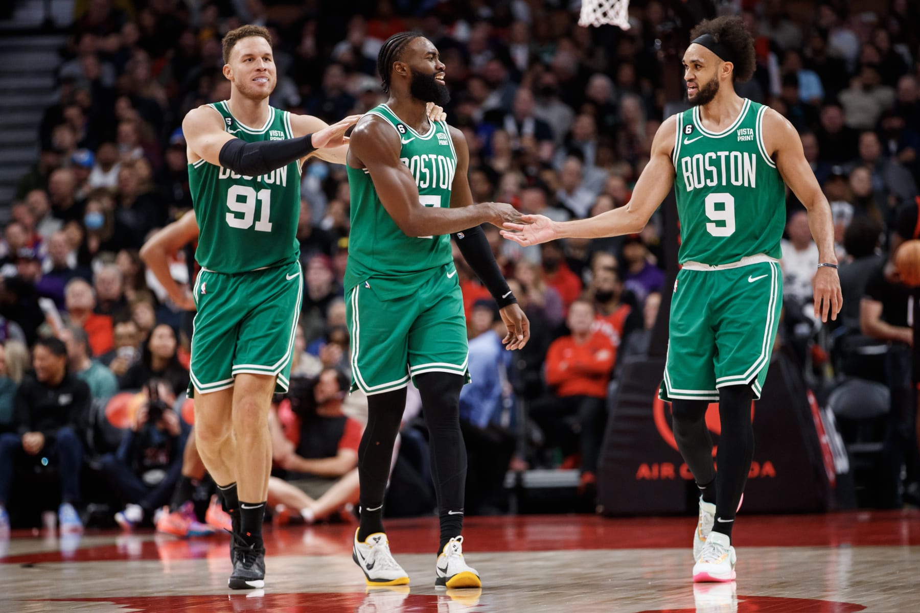 TORONTO, ON - DECEMBER 05: Blake Griffin #91, Jaylen Brown #7 and Derrick White #9 of the Boston Celtics celebrate in the final minutes of the second half of their NBA game against the Toronto Raptors at Scotiabank Arena on December 5, 2022 in Toronto, Canada. NOTE TO USER: User expressly acknowledges and agrees that, by downloading and or using this photograph, User is consenting to the terms and conditions of the Getty Images License Agreement. (Photo by Cole Burston/Getty Images)