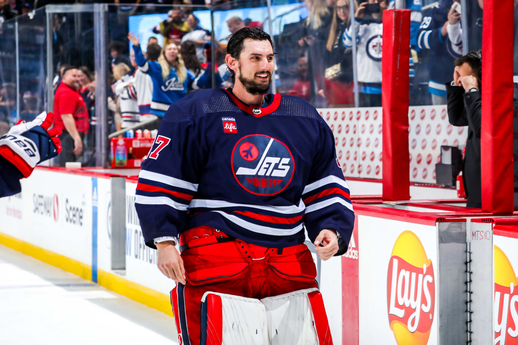 WINNIPEG, CANADA - OCTOBER 24: Goaltender Connor Hellebuyck #37 of the Winnipeg Jets is all smiles after receiving first star honours following a 4-0 shutout victory over the St. Louis Blues at the Canada Life Centre on October 24, 2022 in Winnipeg, Manitoba, Canada. (Photo by Darcy Finley/NHLI via Getty Images)