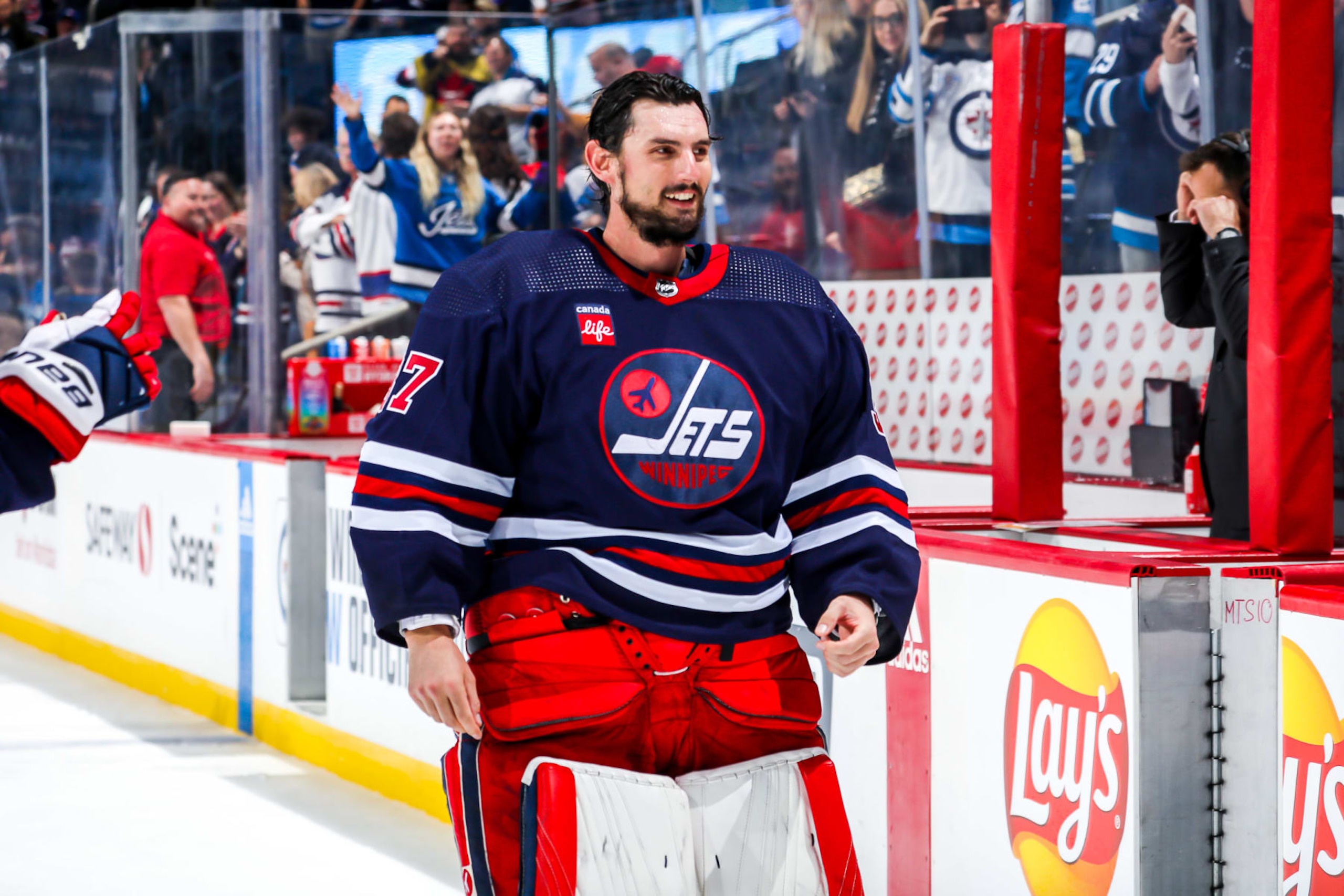 WINNIPEG, CANADA - OCTOBER 24: Goaltender Connor Hellebuyck #37 of the Winnipeg Jets is all smiles after receiving first star honours following a 4-0 shutout victory over the St. Louis Blues at the Canada Life Centre on October 24, 2022 in Winnipeg, Manitoba, Canada. (Photo by Darcy Finley/NHLI via Getty Images)