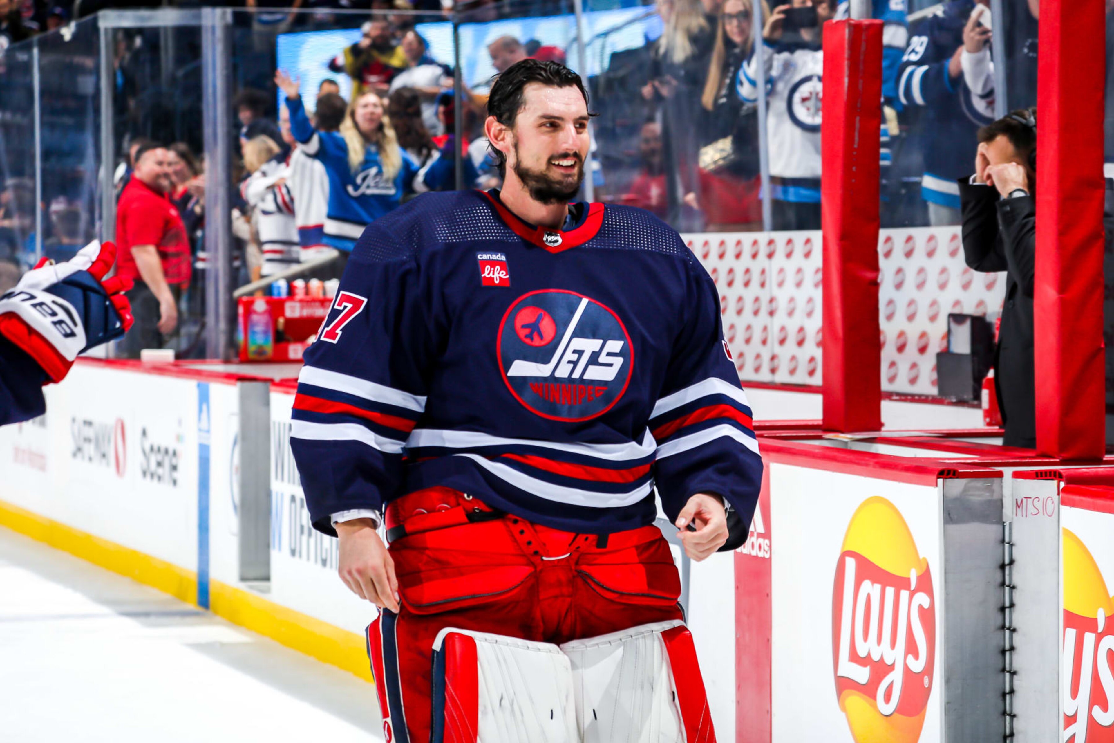 WINNIPEG, CANADA - OCTOBER 24: Goaltender Connor Hellebuyck #37 of the Winnipeg Jets is all smiles after receiving first star honours following a 4-0 shutout victory over the St. Louis Blues at the Canada Life Centre on October 24, 2022 in Winnipeg, Manitoba, Canada. (Photo by Darcy Finley/NHLI via Getty Images)