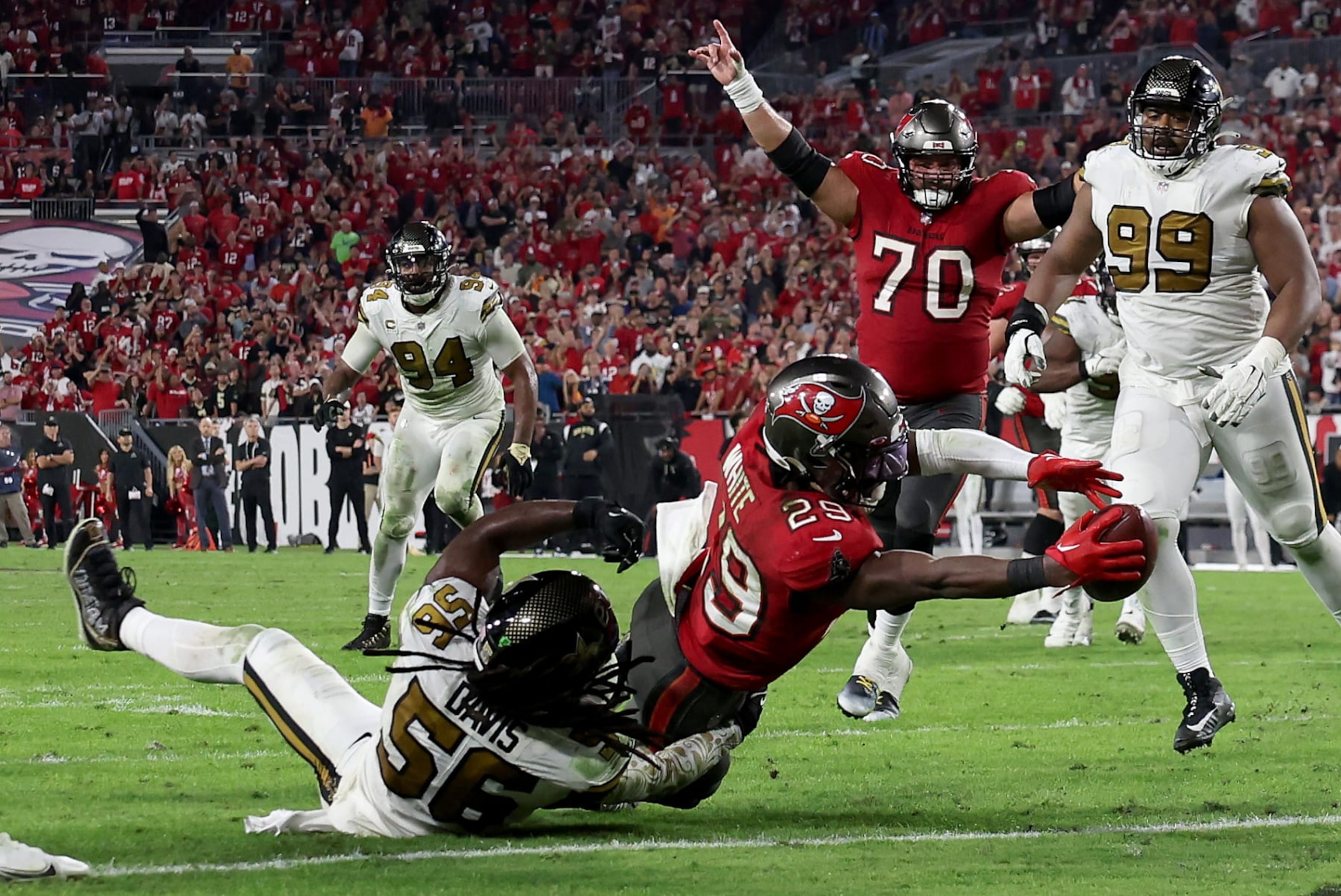 TAMPA, FLORIDA - DECEMBER 05: Rachaad White #29 of the Tampa Bay Buccaneers scores a touchdown against Demario Davis #56 of the New Orleans Saints late in the fourth quarter during the game at Raymond James Stadium on December 05, 2022 in Tampa, Florida. The Tampa Bay Buccaneers defeated the New Orleans Saints with a score of 17 to 16. (Photo by Mike Carlson/Getty Images) TAMPA, FLORIDA - DECEMBER 05: Rachaad White #29 of the Tampa Bay Buccaneers scores a touchdown against Demario Davis #56 of the New Orleans Saints late in the fourth quarter during the game at Raymond James Stadium on December 05, 2022 in Tampa, Florida. The Tampa Bay Buccaneers defeated the New Orleans Saints with a score of 17 to 16. (Photo by Mike Carlson/Getty Images)