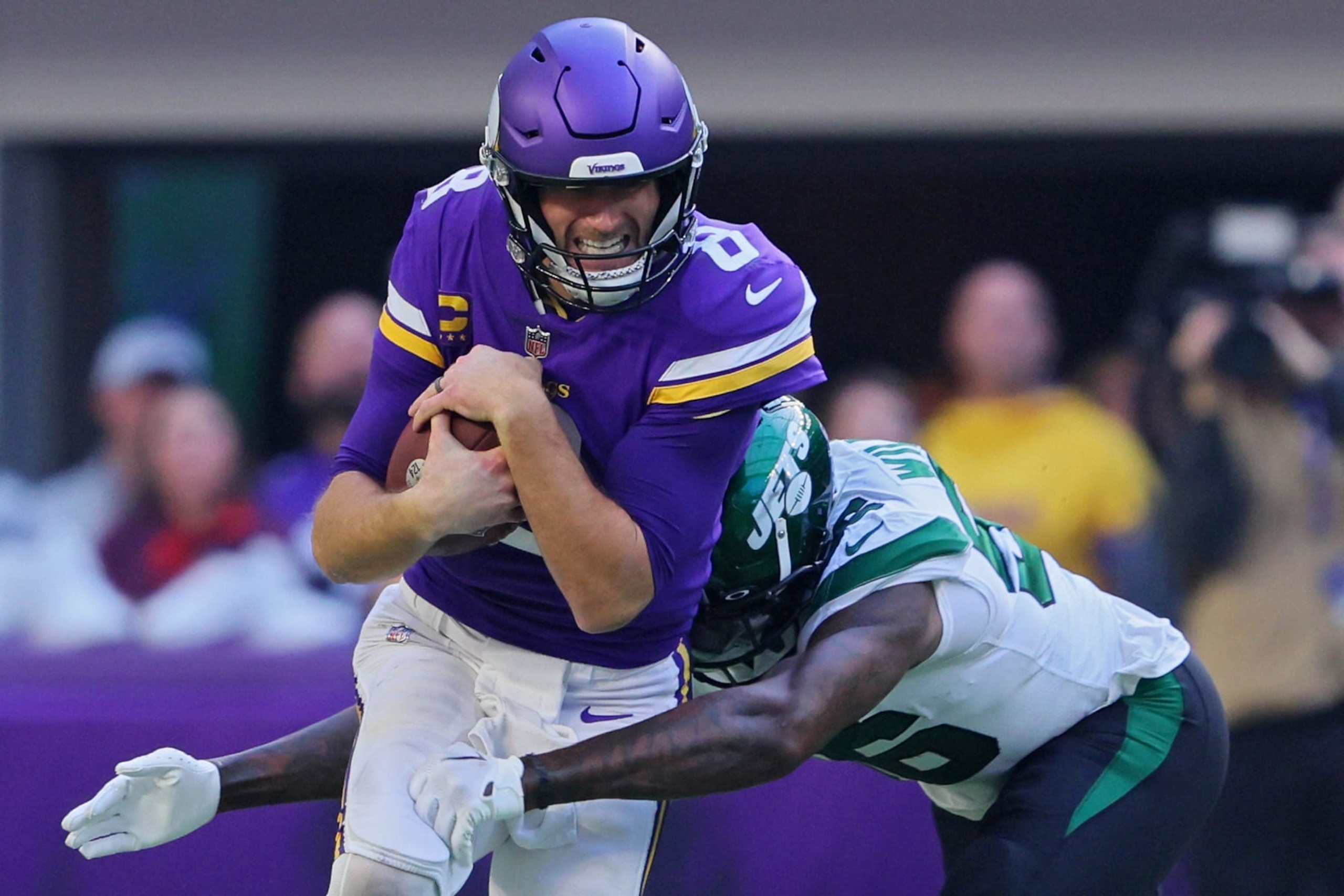 MINNEAPOLIS, MINNESOTA - DECEMBER 04: Quincy Williams #56 of the New York Jets tackles Kirk Cousins #8 of the Minnesota Vikings during the second quarter at U.S. Bank Stadium on December 04, 2022 in Minneapolis, Minnesota. (Photo by Adam Bettcher/Getty Images)