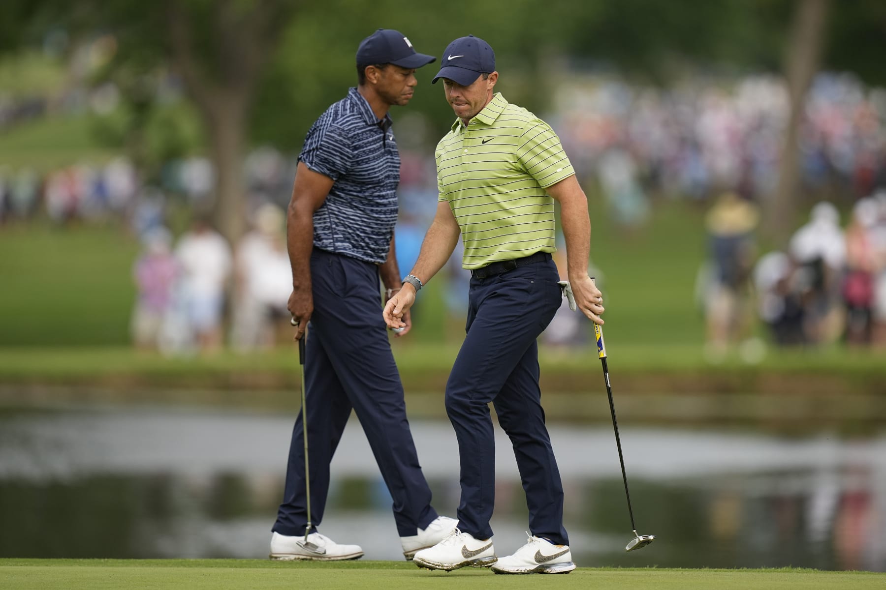 Rory McIlroy, of Northern Ireland, and Tiger Woods walk on the 11th green during the first round of the PGA Championship golf tournament, Thursday, May 19, 2022, in Tulsa, Okla. (AP Photo/Eric Gay)