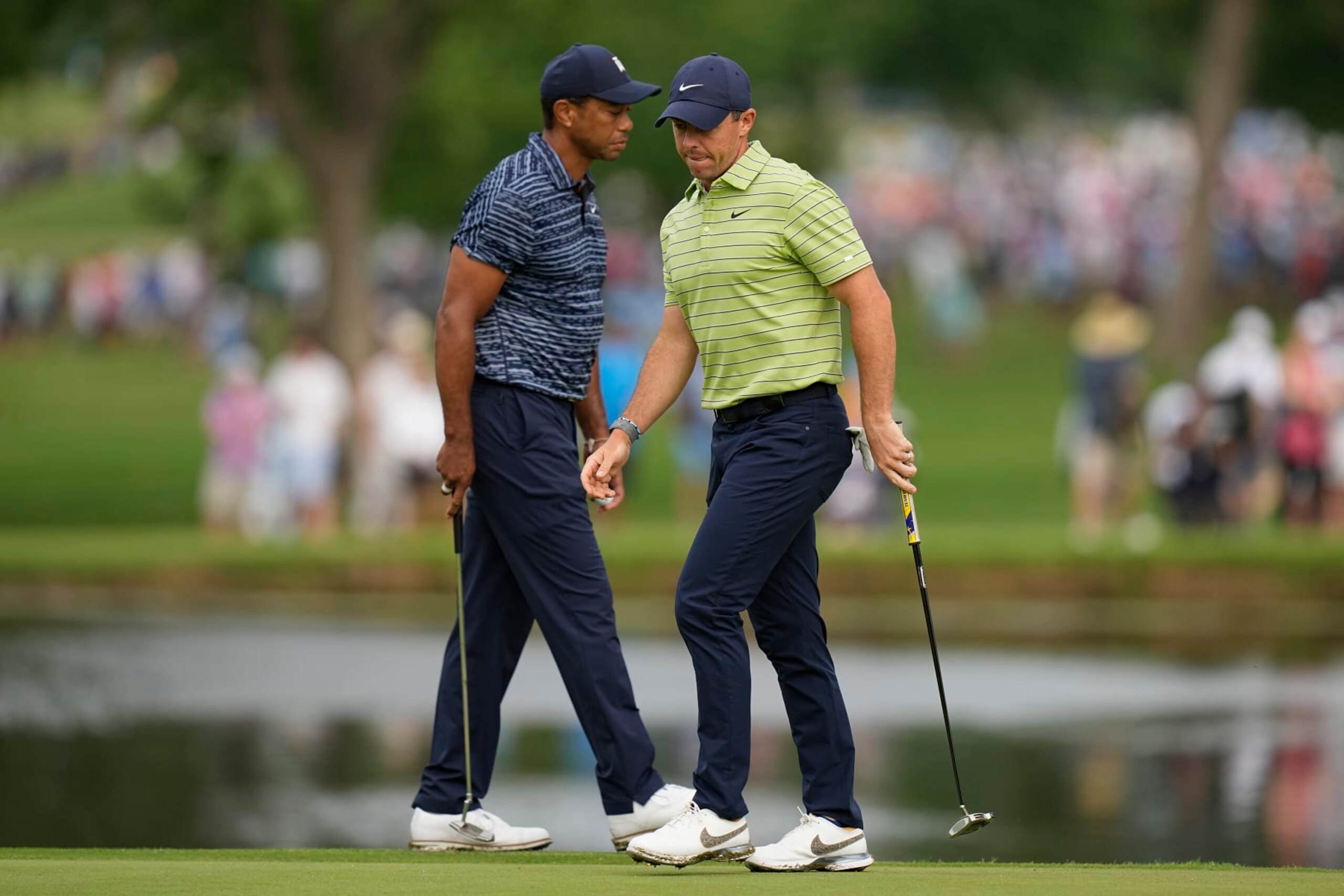 Rory McIlroy, of Northern Ireland, and Tiger Woods walk on the 11th green during the first round of the PGA Championship golf tournament, Thursday, May 19, 2022, in Tulsa, Okla. (AP Photo/Eric Gay)