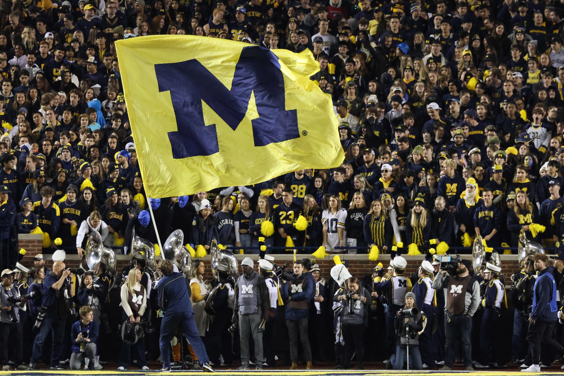 ANN ARBOR, MI - OCTOBER 29:  A Michigan cheerleader waves a large flag with the Michigan logo on it during a college football game between the Michigan State Spartans and the Michigan Wolverines on October 29, 2022 at Michigan Stadium in Ann Arbor, Michigan.  (Photo by Scott W. Grau/Icon Sportswire via Getty Images)