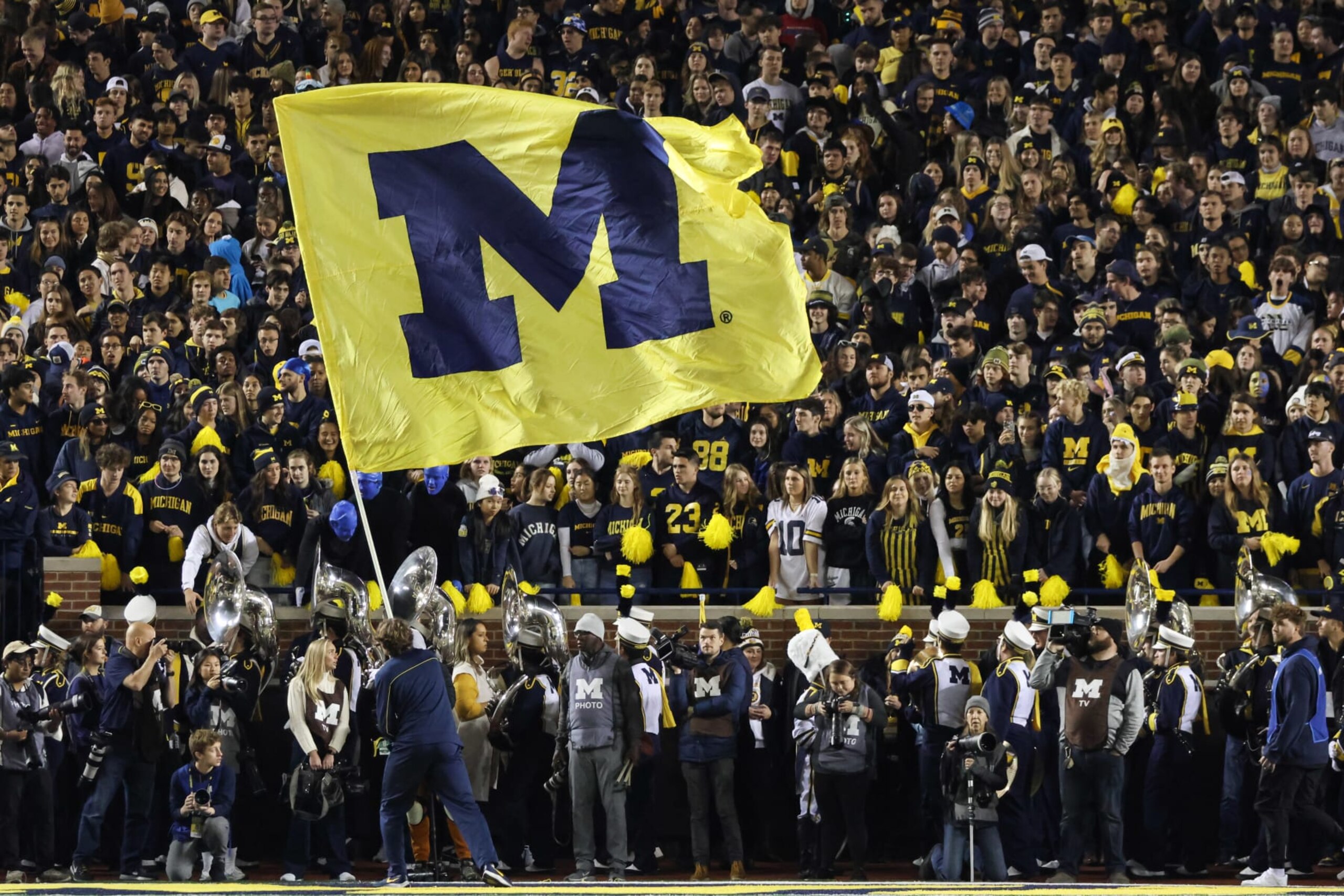 ANN ARBOR, MI - OCTOBER 29: A Michigan cheerleader waves a large flag with the Michigan logo on it during a college football game between the Michigan State Spartans and the Michigan Wolverines on October 29, 2022 at Michigan Stadium in Ann Arbor, Michigan. (Photo by Scott W. Grau/Icon Sportswire via Getty Images) ANN ARBOR, MI - OCTOBER 29: A Michigan cheerleader waves a large flag with the Michigan logo on it during a college football game between the Michigan State Spartans and the Michigan Wolverines on October 29, 2022 at Michigan Stadium in Ann Arbor, Michigan. (Photo by Scott W. Grau/Icon Sportswire via Getty Images)
