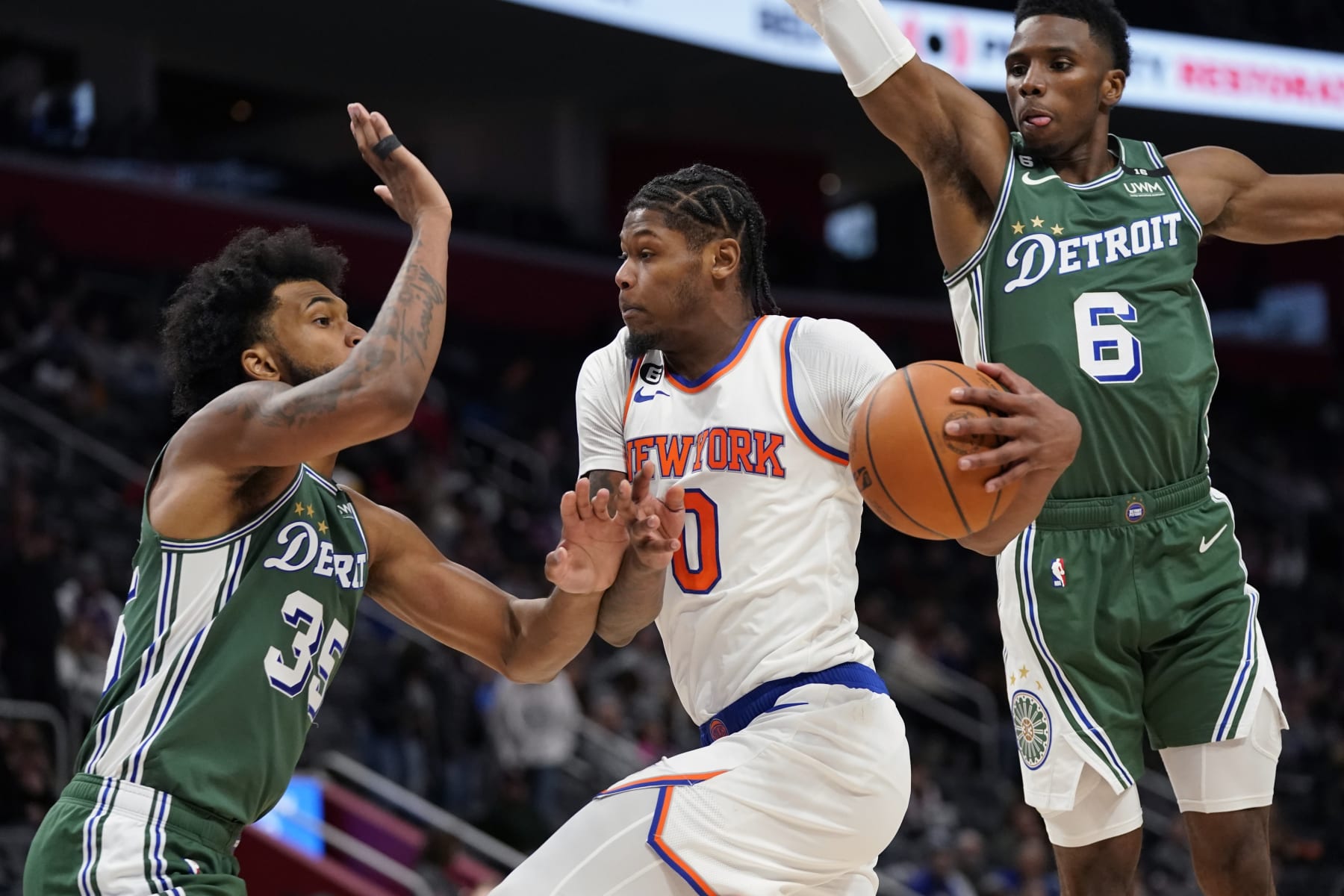 New York Knicks forward Cam Reddish (0) passes as Detroit Pistons forward Marvin Bagley III (35) and guard Hamidou Diallo (6) defend during the second half of an NBA basketball game, Tuesday, Nov. 29, 2022, in Detroit. (AP Photo/Carlos Osorio)