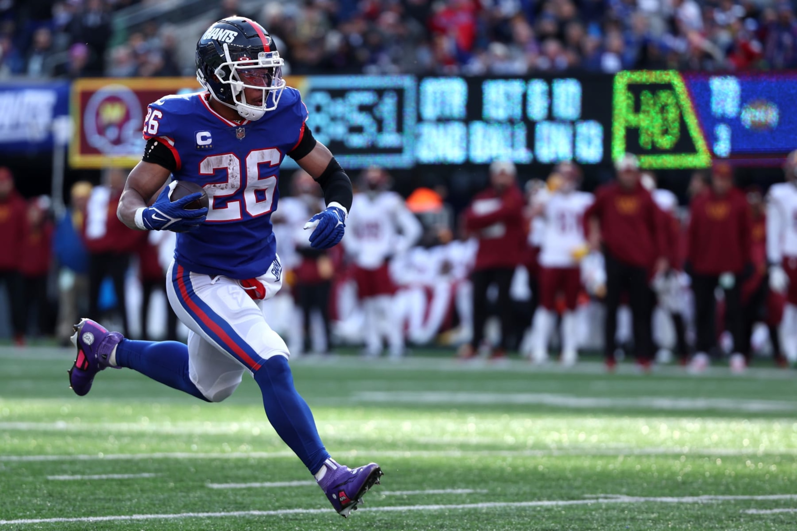 EAST RUTHERFORD, NEW JERSEY - DECEMBER 04: Saquon Barkley #26 of the New York Giants runs with the ball in the second quarter of a game against the Washington Commanders at MetLife Stadium on December 04, 2022 in East Rutherford, New Jersey. (Photo by Al Bello/Getty Images)