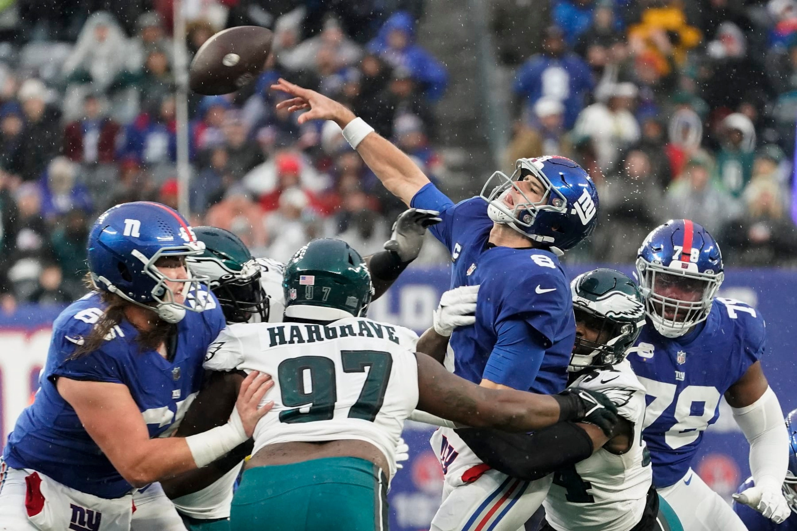 New York Giants quarterback Daniel Jones (8) takes a hit from Philadelphia Eagles linebacker Shaun Bradley (54) during the fourth quarter12 of an NFL football game, Sunday, Dec. 11, 2022, in East Rutherford, N.J. (AP Photo/John Minchillo)