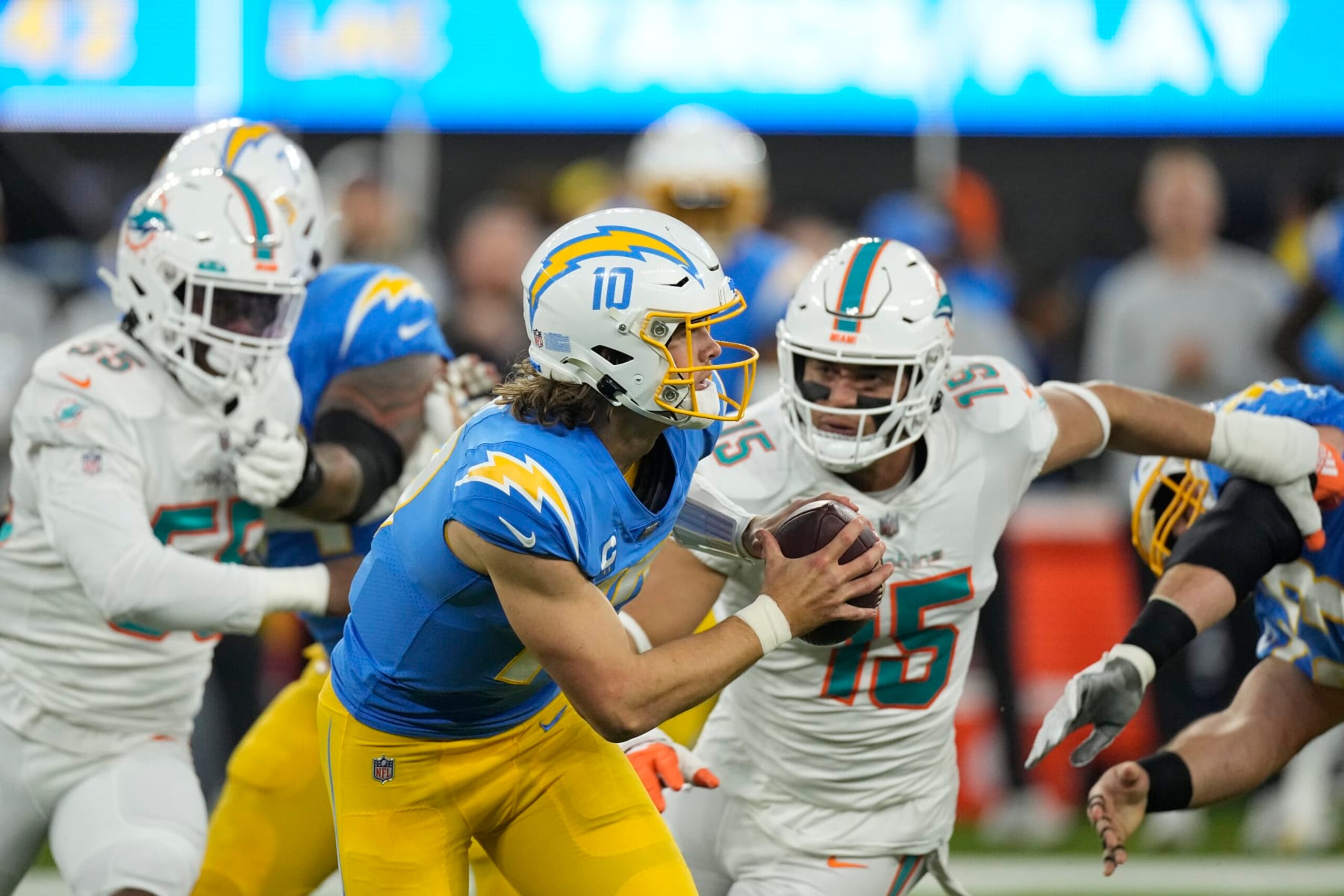 Los Angeles Chargers quarterback Justin Herbert (10) is chased by -Miami Dolphins linebacker Jaelan Phillips (15) during the first half of an NFL football game Sunday, Dec. 11, 2022, in Inglewood, Calif. (AP Photo/Mark J. Terrill)
