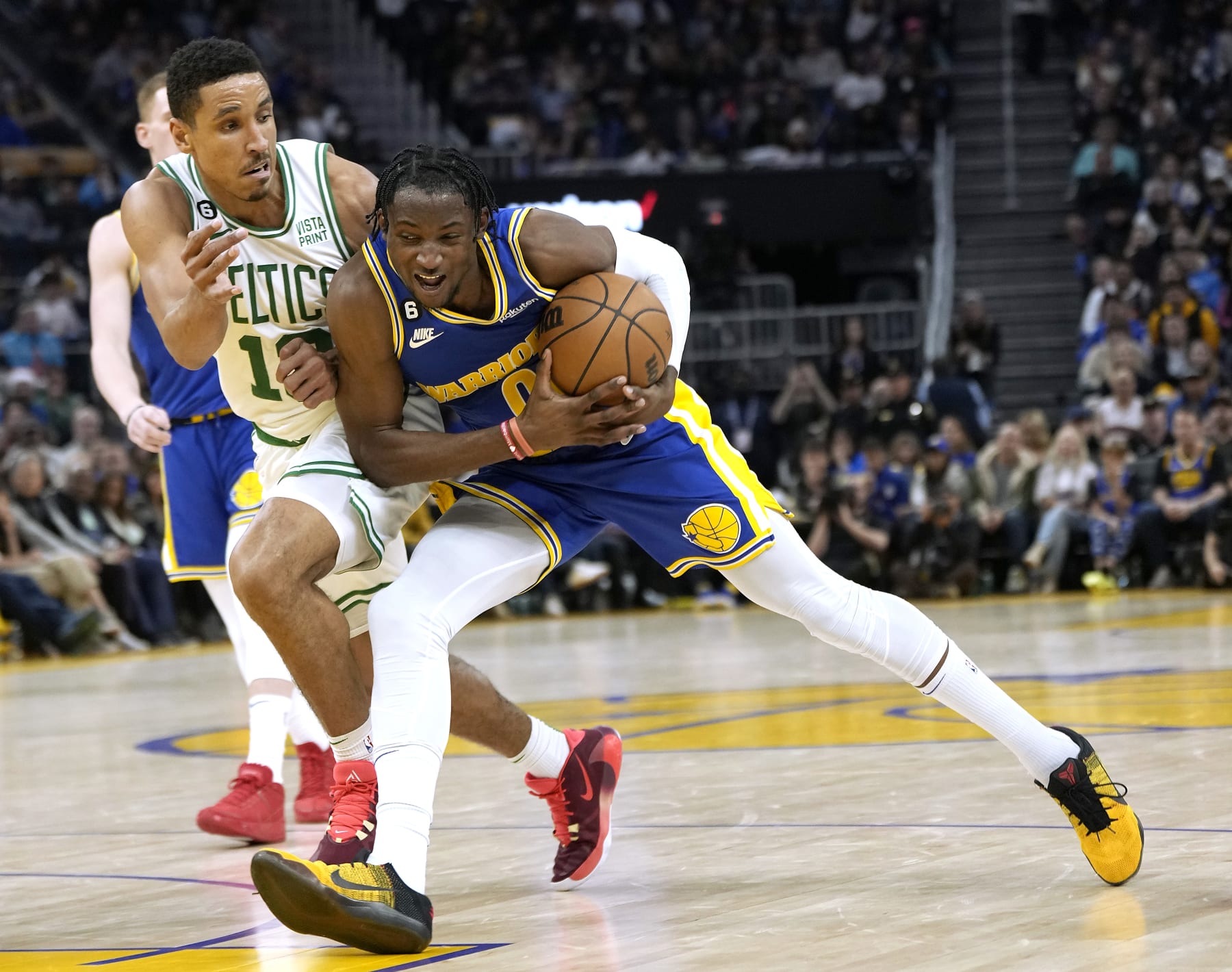 SAN FRANCISCO, CALIFORNIA - DECEMBER 10: Jonathan Kuminga #00 of the Golden State Warriors drives towards the basket on Malcolm Brogdon #13 of the Boston Celtics during the fourth quarter of an NBA basketball game at Chase Center on December 10, 2022 in San Francisco, California. NOTE TO USER: User expressly acknowledges and agrees that, by downloading and or using this photograph, User is consenting to the terms and conditions of the Getty Images License Agreement. (Photo by Thearon W. Henderson/Getty Images)