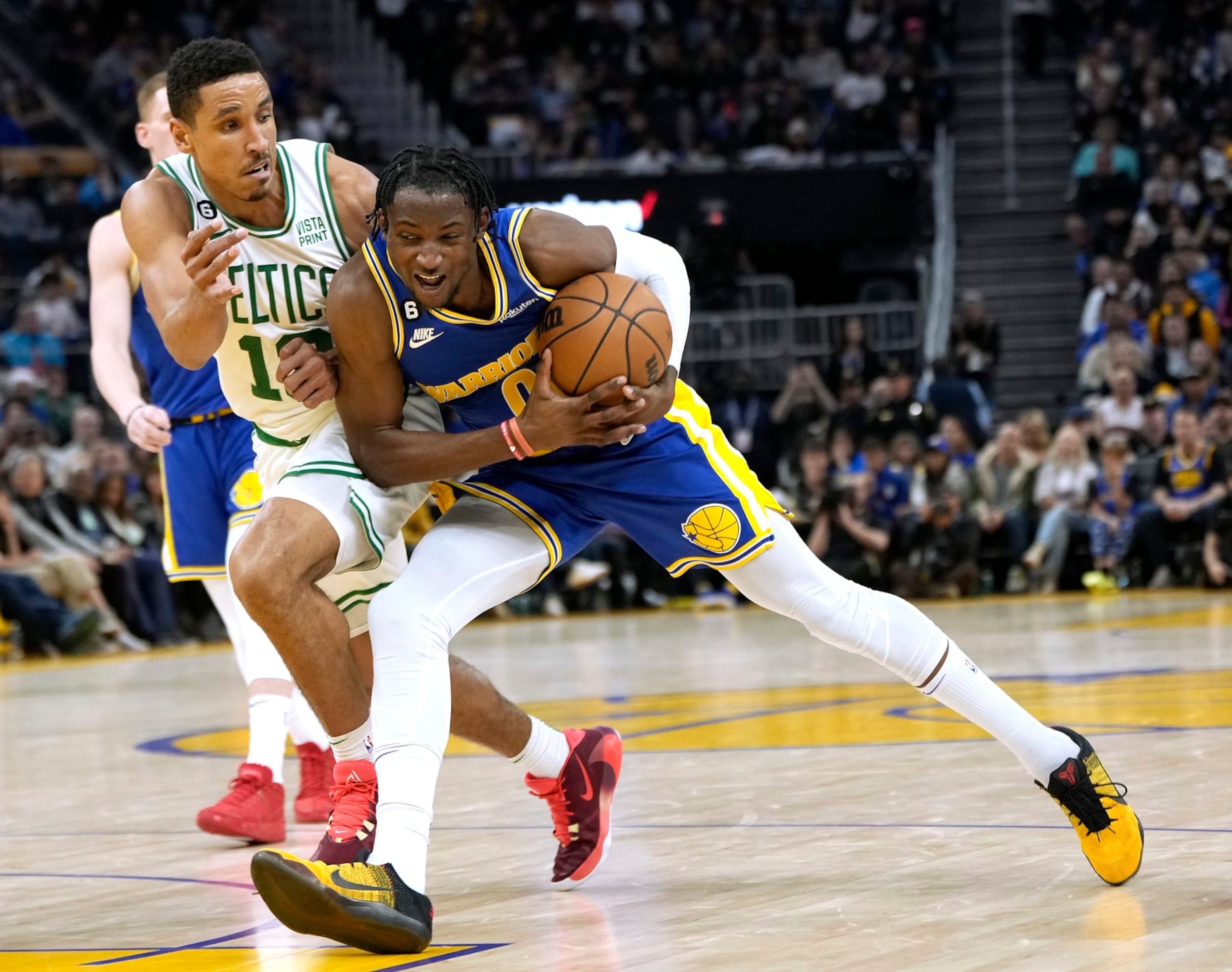 SAN FRANCISCO, CALIFORNIA - DECEMBER 10: Jonathan Kuminga #00 of the Golden State Warriors drives towards the basket on Malcolm Brogdon #13 of the Boston Celtics during the fourth quarter of an NBA basketball game at Chase Center on December 10, 2022 in San Francisco, California. NOTE TO USER: User expressly acknowledges and agrees that, by downloading and or using this photograph, User is consenting to the terms and conditions of the Getty Images License Agreement. (Photo by Thearon W. Henderson/Getty Images)